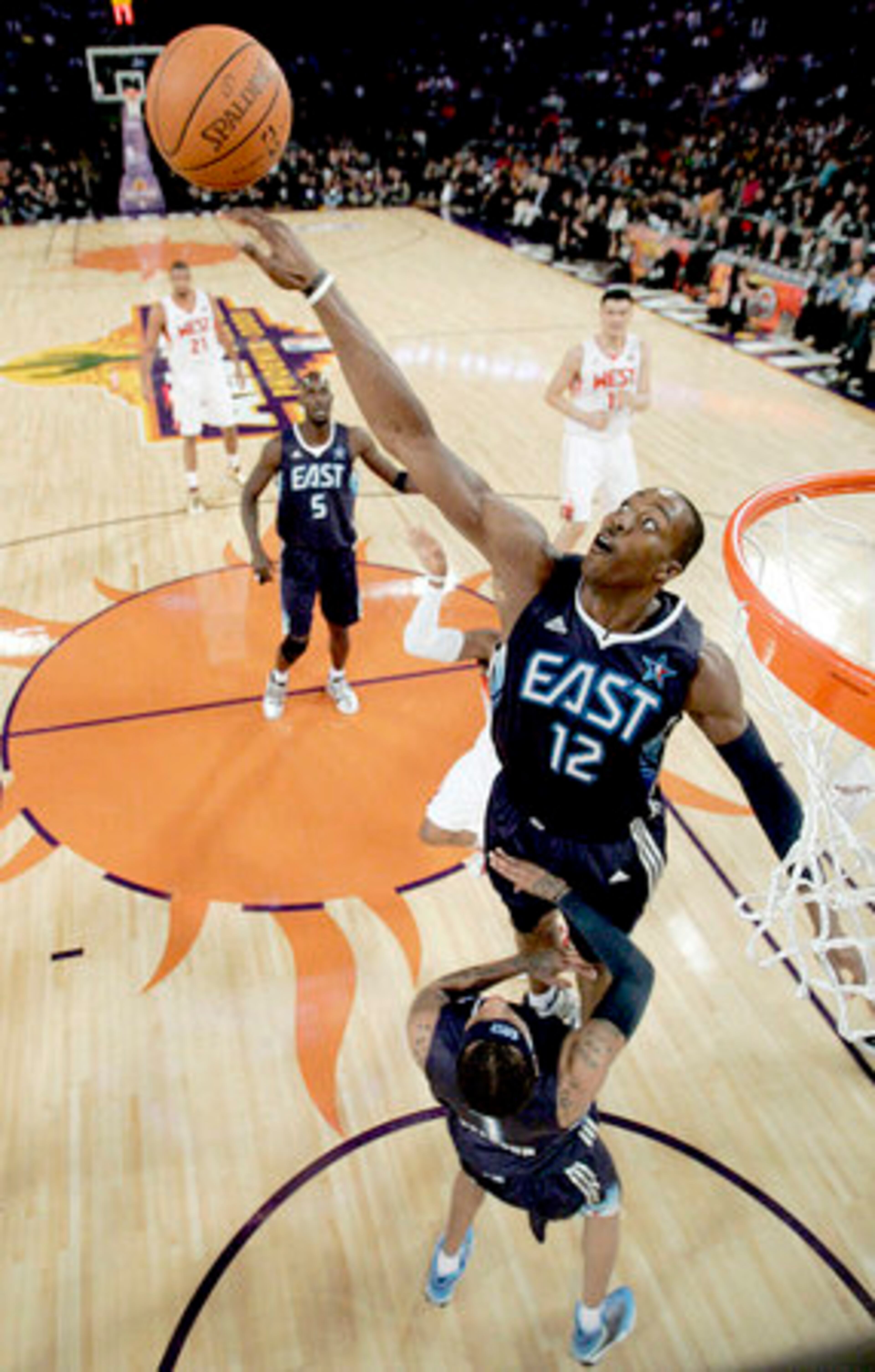 Dwight Howard reaches up high to block a floating shot by the Hornets' Chris Paul.
