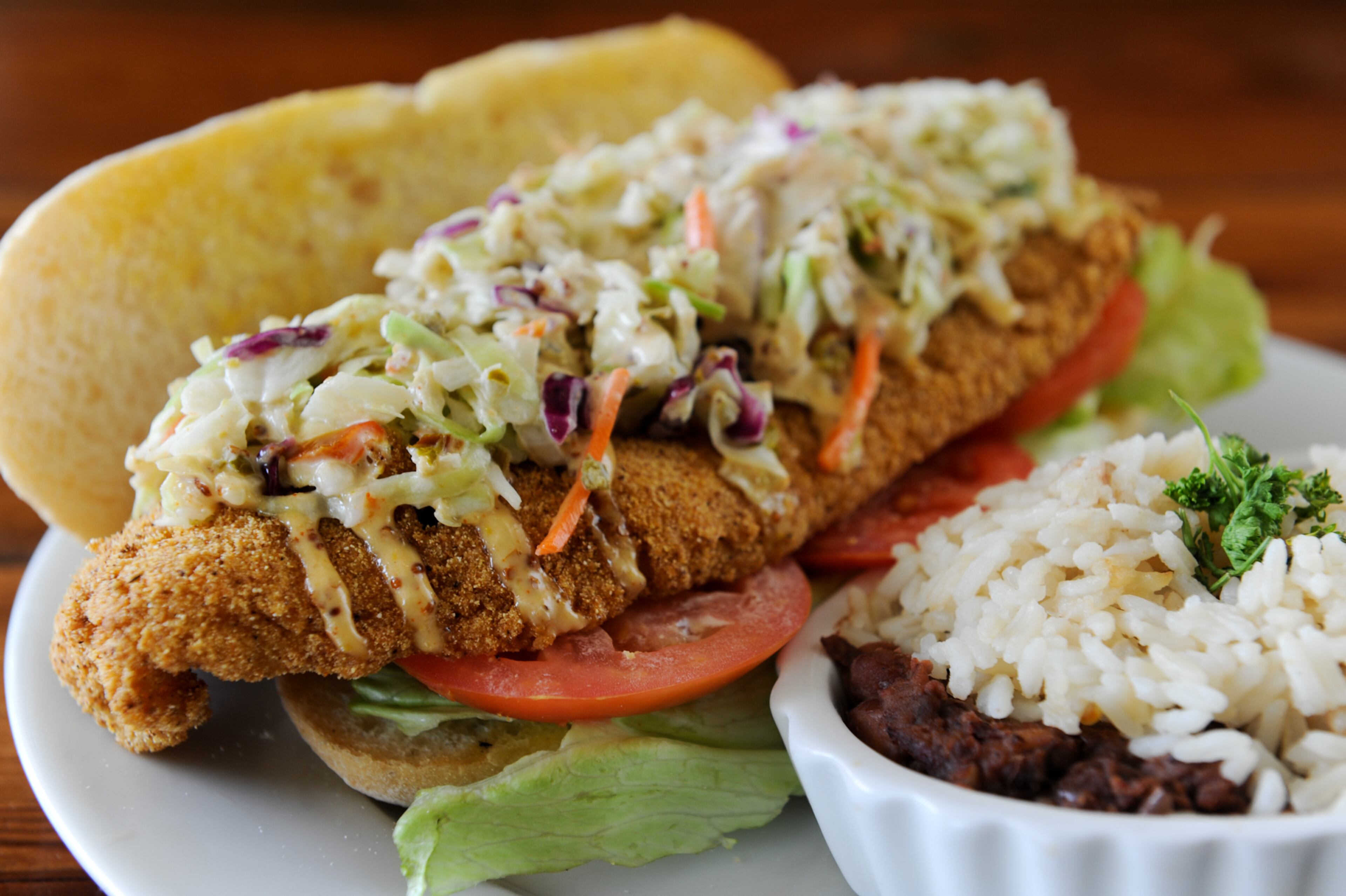 "The po’ boys are classics — dressed with care, easy to assembled and eat. But I do have a couple of complaints. 1) Our oysters were perfectly juiceless. 2) The Leidenheimer bread imported from New Orleans hadn’t been warmed enough to crisp the crust. That crispness makes it for me. Still, I found the sandwich enjoyable, aided by its tasty side of red beans and rice."