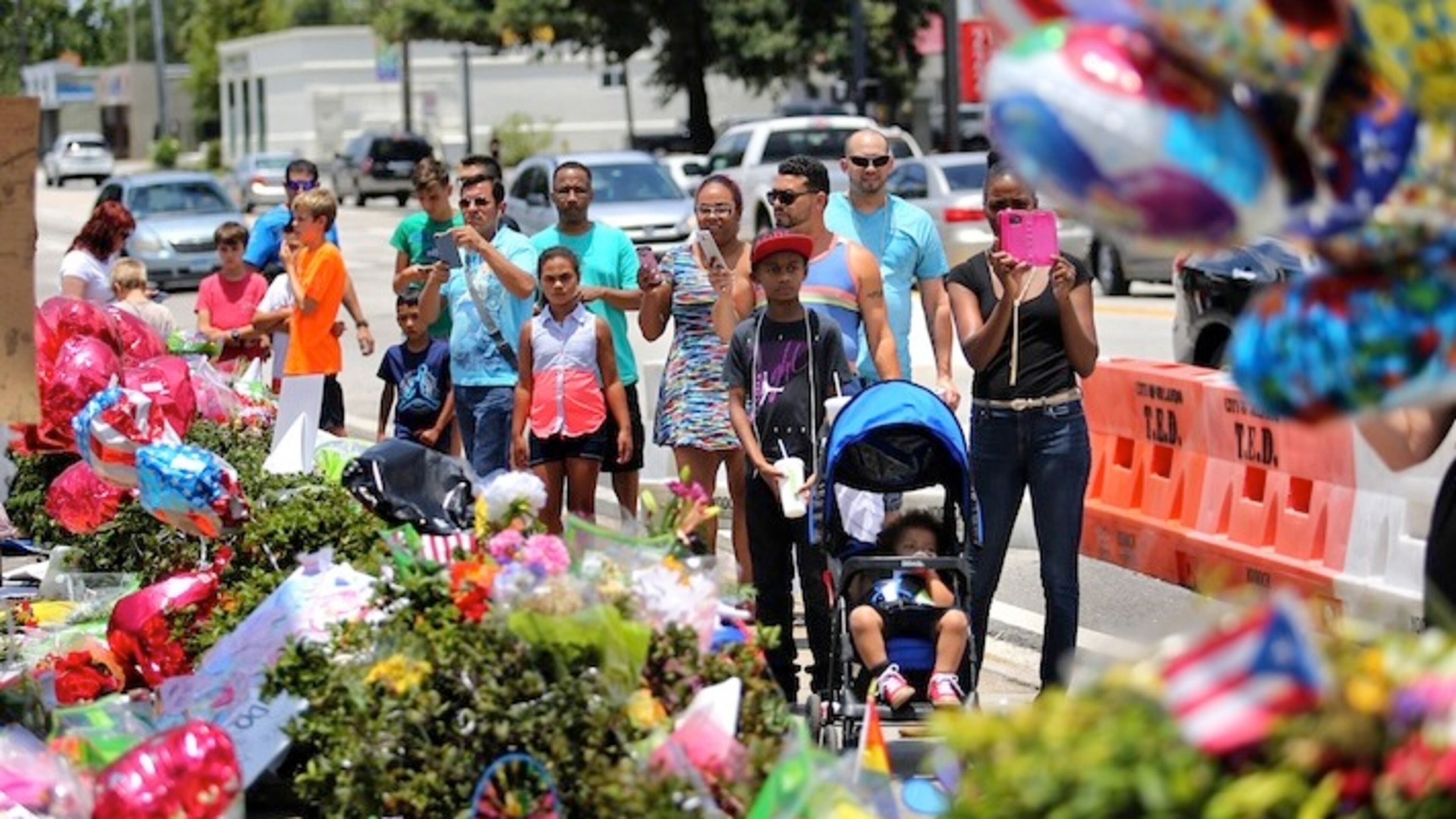 Balloons fill the scene as visitors continue to flock to the roadside memorial at the Pulse nightclub in Orlando, Fla., Wednesday, June 29, 2016. Forty-nine people were shot and killed by a gunman in the largest massacre in U.S. history, on June 12. (Joe Burbank/Orlando Sentinel via AP)
