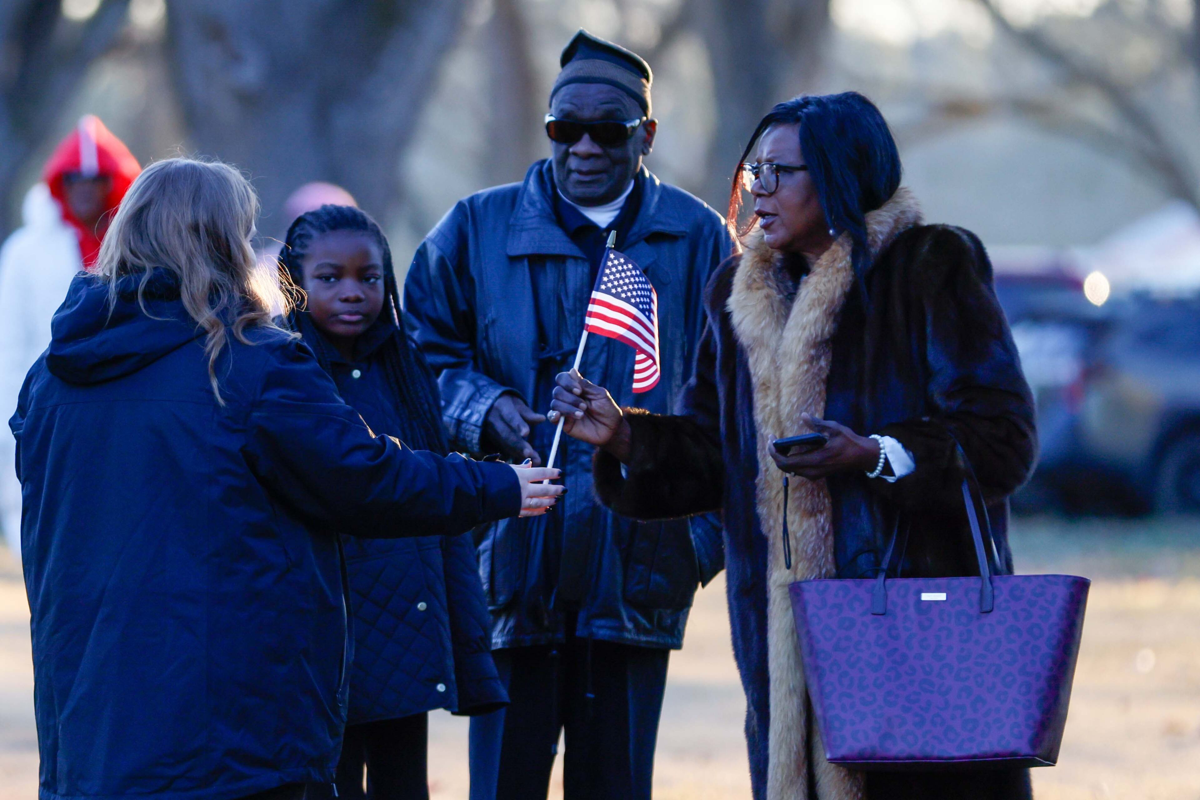 A worker at Phoebe Sumter Medical Center hands American flags to people as they arrive for the tribute to President Jimmy Carter. This event is the starting point of a series of public ceremonies honoring his life and legacy on Saturday, January 4, 2025.
(Miguel Martinez/AJC)