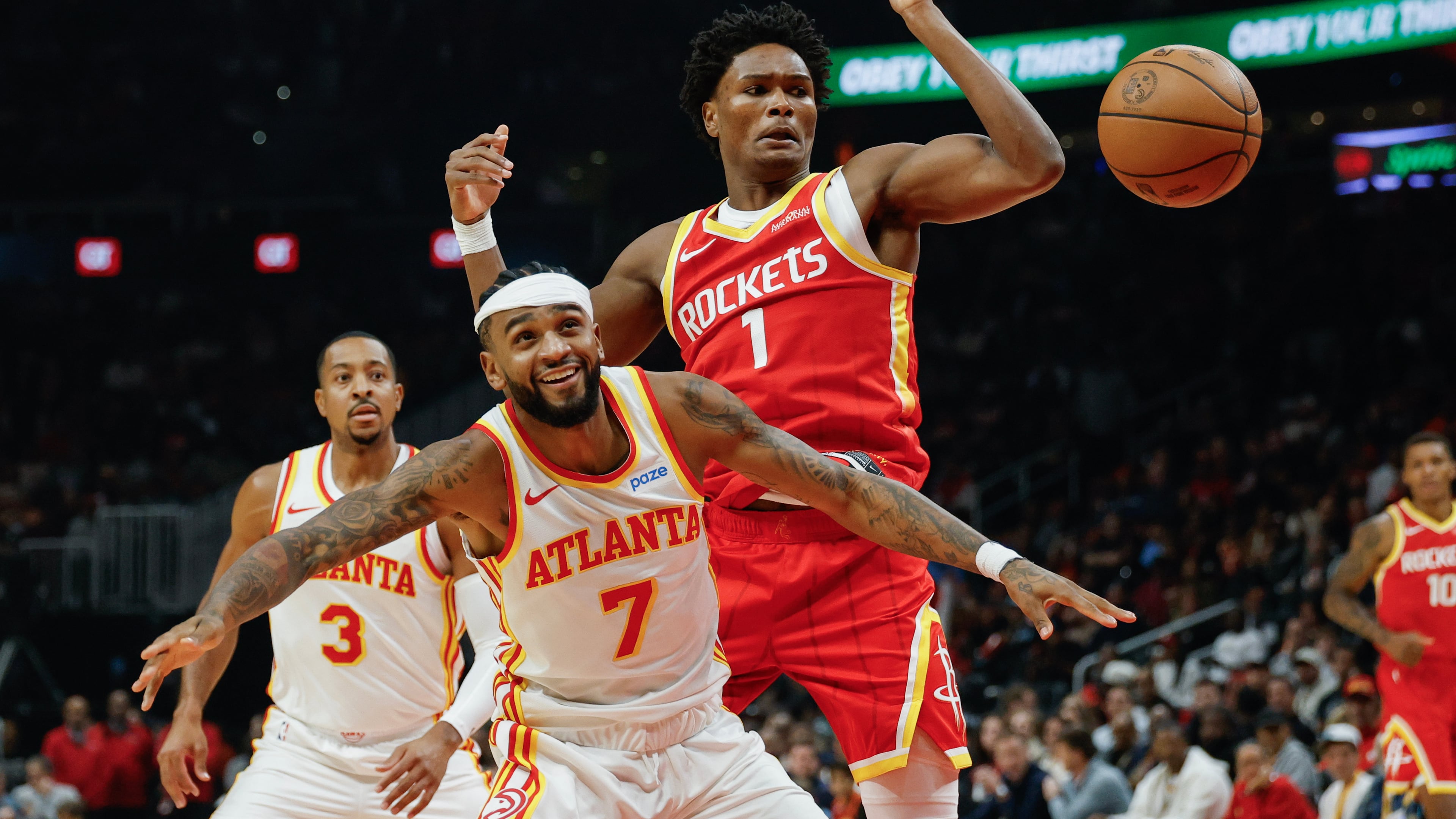 Rockets guard Amen Thompson (center right) and Hawks guard Nickeil Alexander-Walker compete for a rebound Saturday, Oct. 24, 2026, in Atlanta. Houston won 121-114. (Erik S. Lesser/AP)