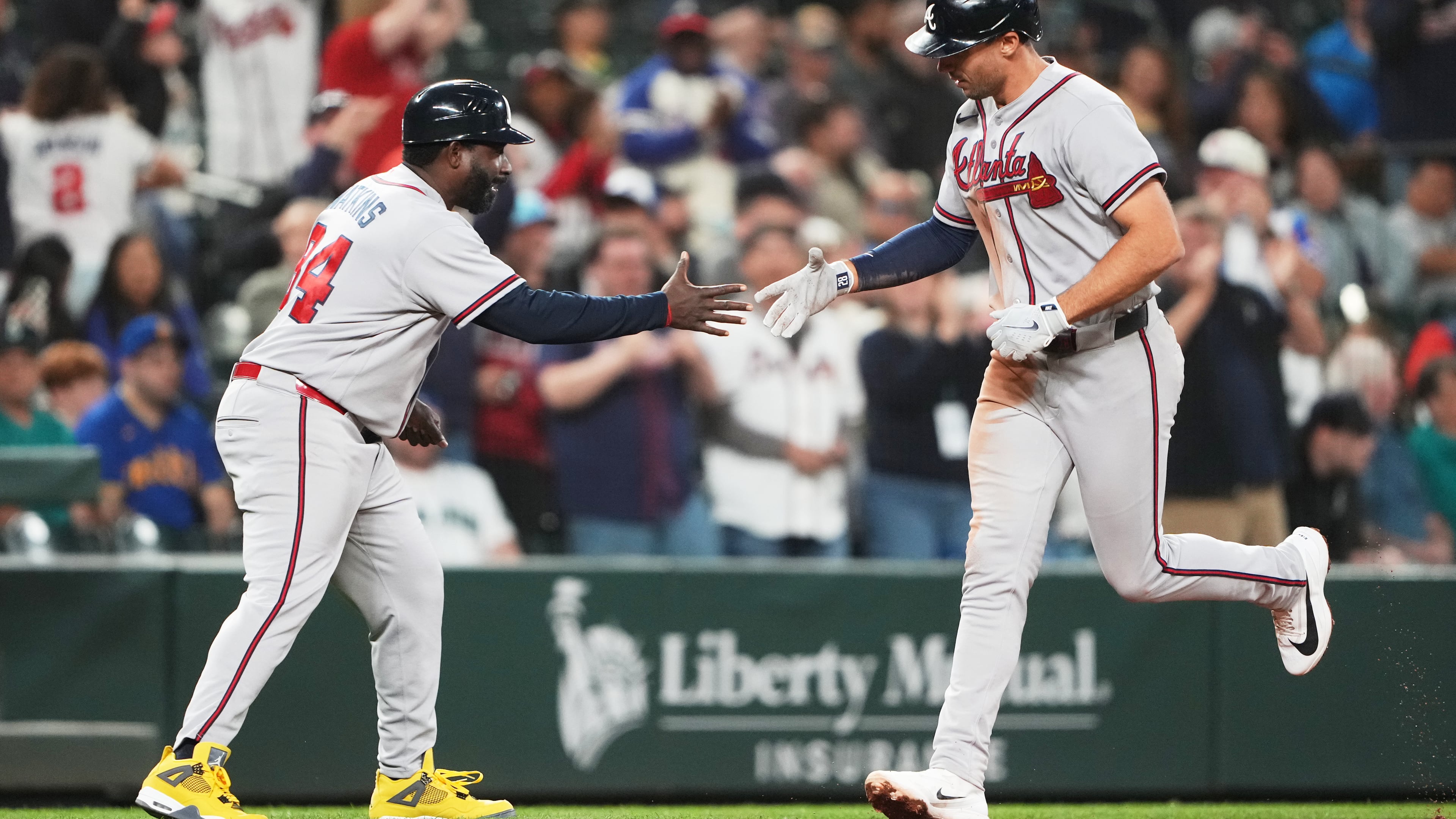 Atlanta Braves' Matt Olson greets third base coach Tommy Watkins while jogging home after hitting a solo home run against the Seattle Mariners during the ninth inning of a baseball game, Tuesday, May 5, 2026, in Seattle. (AP Photo/Lindsey Wasson)
