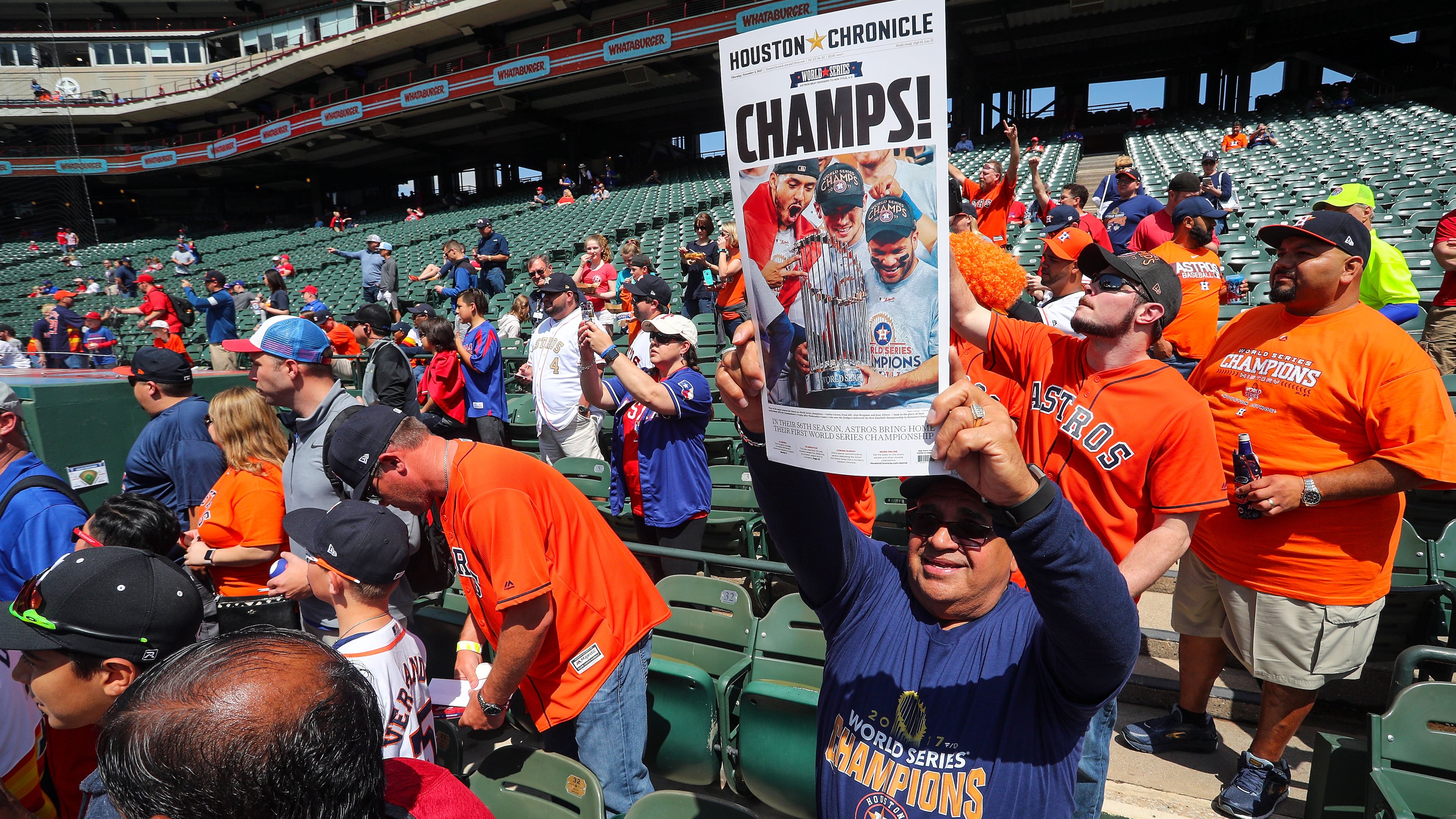 ARLINGTON, TX - MARCH 29: A Houston Astros fan holds up a newspaper cover with a photo from the World Series as the team starts batting practice before the Opening Day game agaisnt the Texas Rangers at Globe Life Park in Arlington on March 29, 2018 in Arlington, Texas. (Photo by Richard Rodriguez/Getty Images)