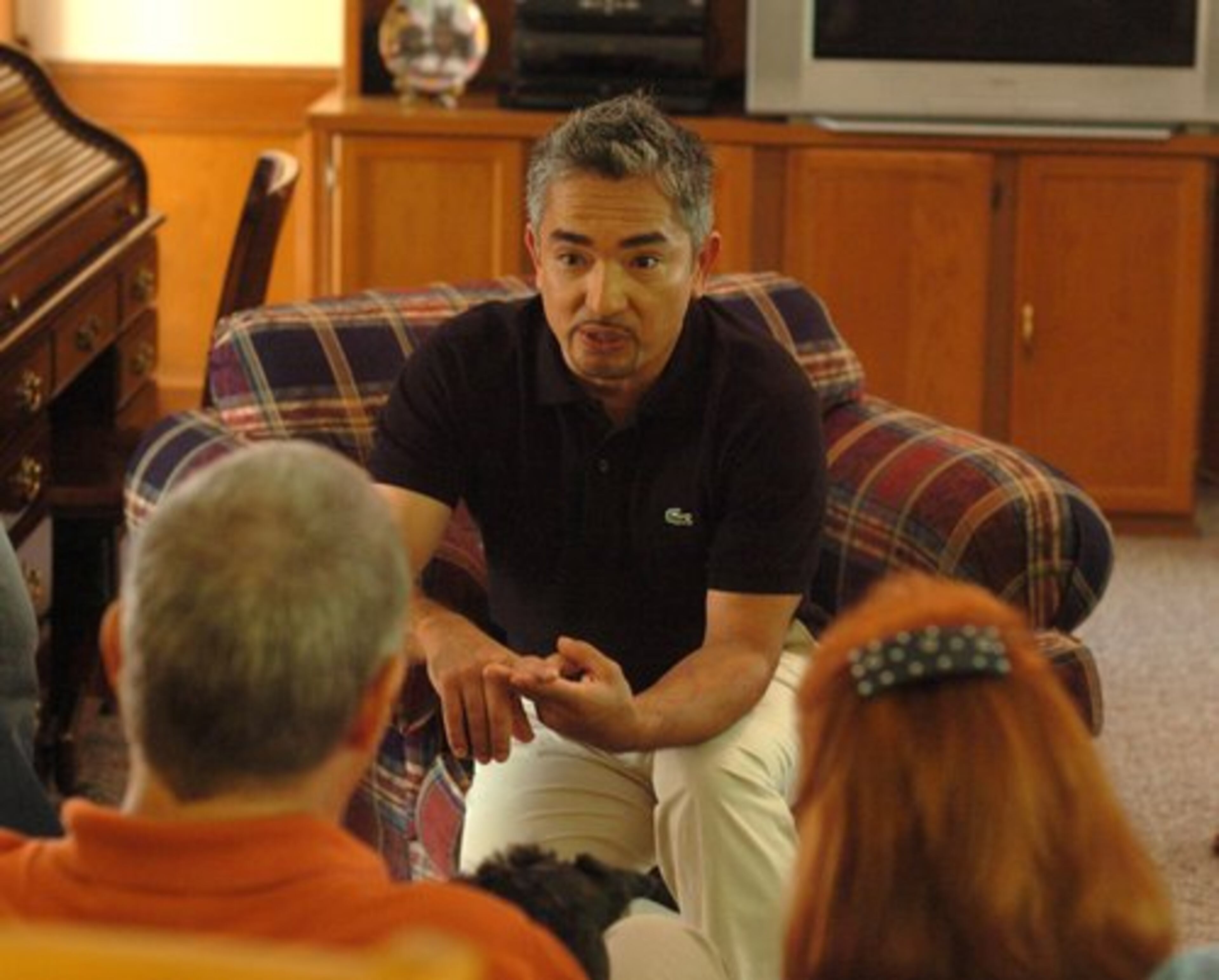 Cesar Millan talks with Jim and Marcia Sasser prior to filming one of Millan's television shows for the National Geographic TV channel. Millan spent about four hours in the Sassers' home working with their three dogs.