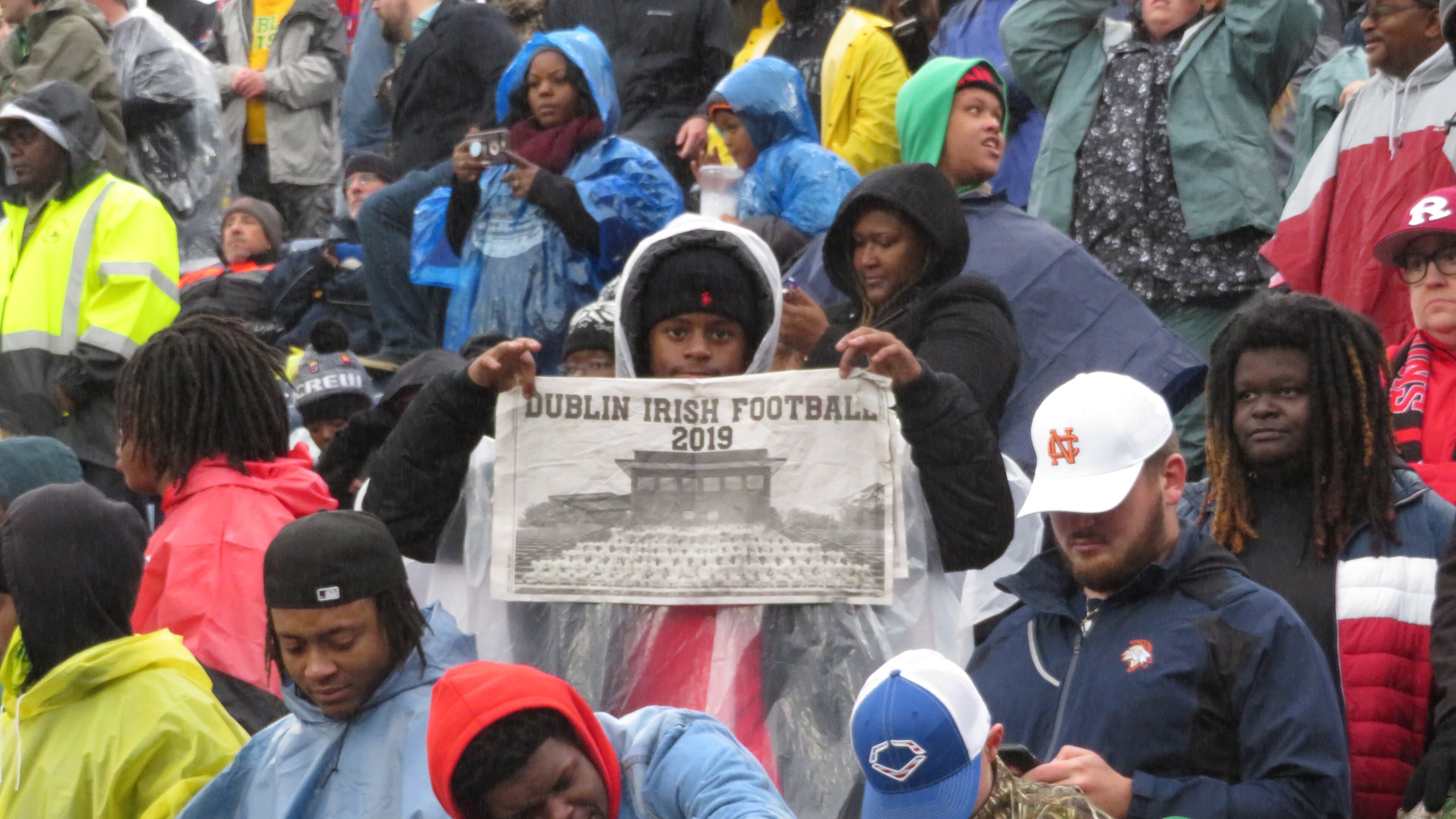 A Dublin Fighting Irish fan holds up a newspaper in the waning moments of Dublin's 42-32 win over the Brooks County Trojans in the Class AA championship on Friday, 13, Dec. 2019 at Georgia State Stadium. (Adam Krohn/for the AJC)