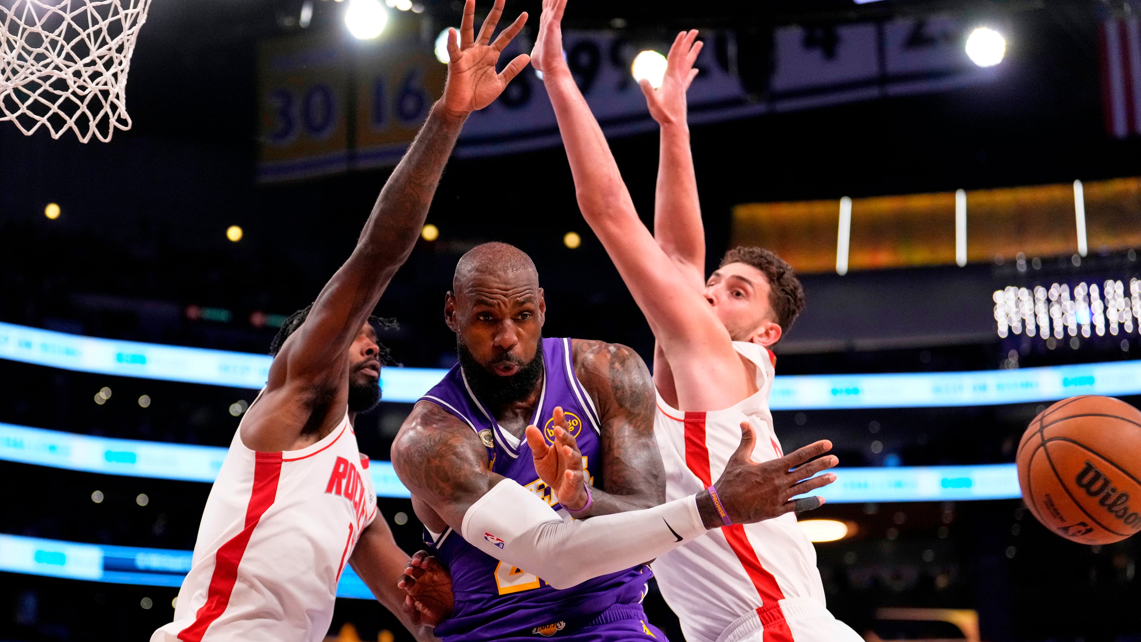 Los Angeles Lakers forward LeBron James, center, passes the ball as Houston Rockets forward Tari Eason, left, and center Alperen Sengun defend during the first half in Game 5 of a first-round NBA playoffs basketball series Wednesday, April 29, 2026, in Los Angeles. (AP Photo/Mark J. Terrill)