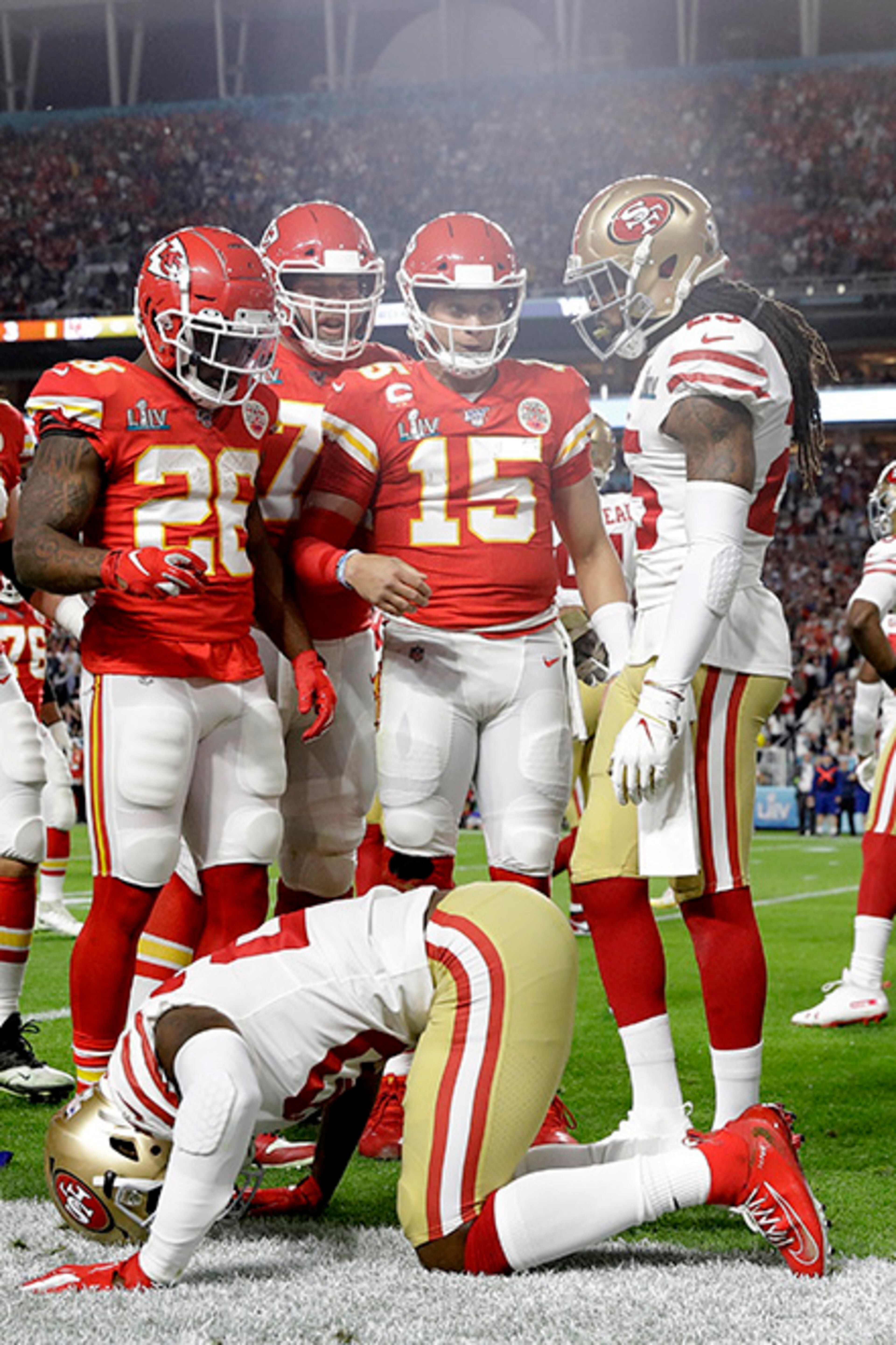 San Francisco 49ers' Jimmie Ward (bottom) sits injured after tackling Kansas City Chiefs quarterback Patrick Mahomes (15) during the first half of Super Bowl 54 Sunday, Feb. 2, 2020, in Miami Gardens, Fla.