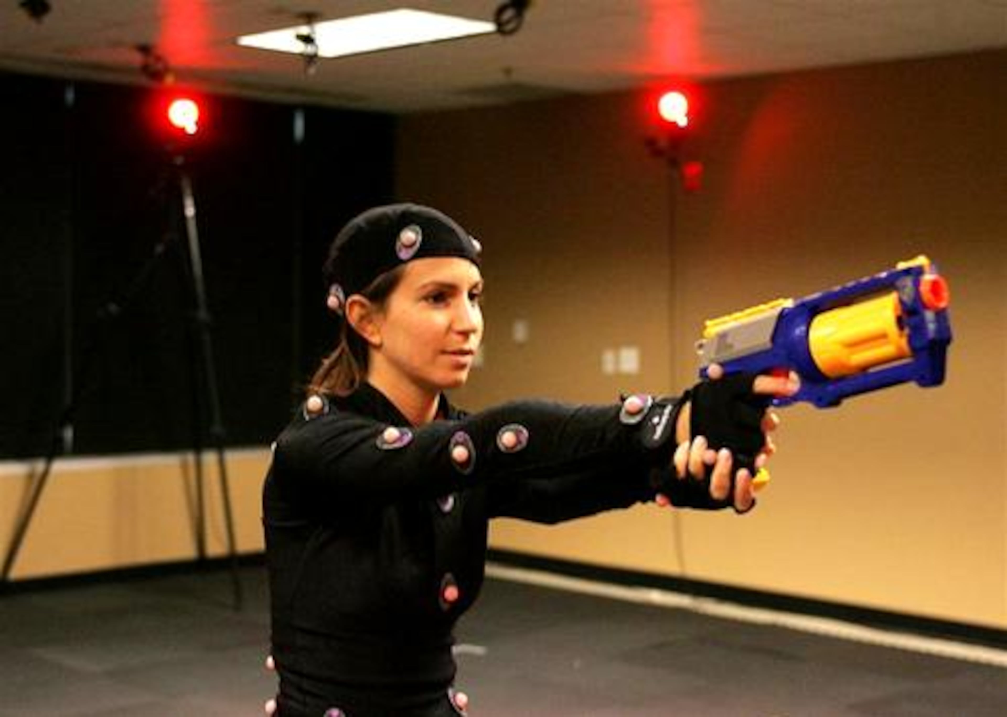 Michal Adam runs on a treadmill while aiming a weapon during a motion capture session at Hi-Rez Studios in Alpharetta. Multiple cameras around the room capture the "markers" on Adam to create a three dimensional image.
