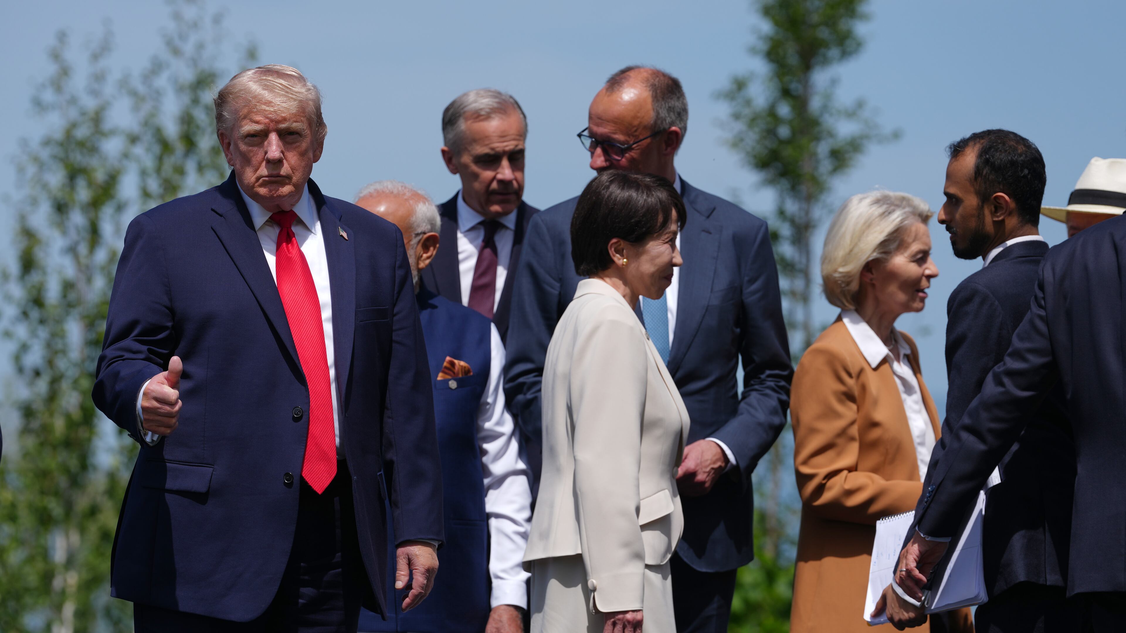 U.S. President Donald Trump, left, gestures prior to a group photo of G7 leaders and invited nations during the G7 summit in Evian-les-Bains, France, Tuesday, June 16, 2026. (AP Photo/Thibault Camus)