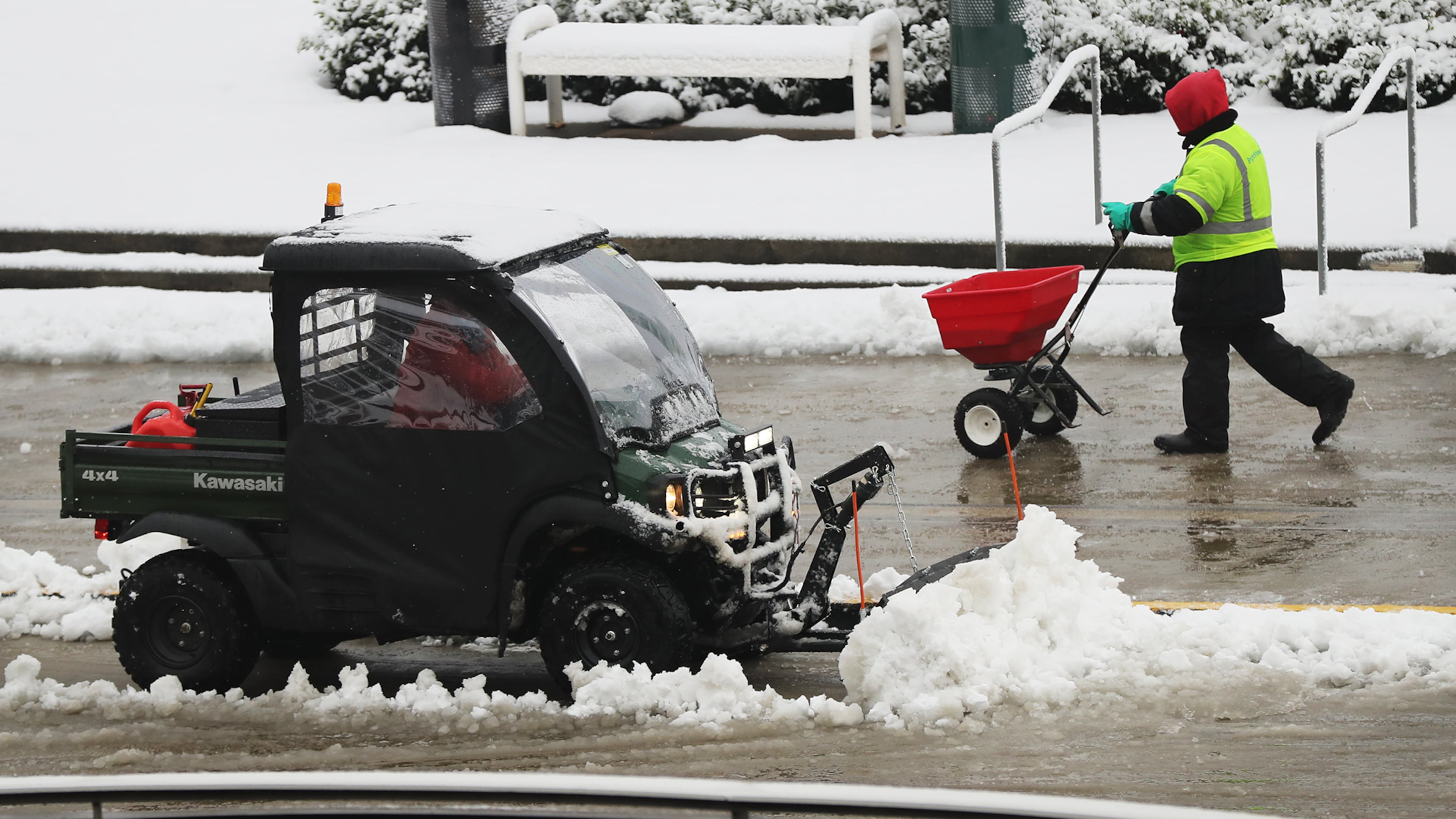December 9, 2017 Atlanta: A worker spreads salt while a plow works to clear the road in front of the Georgia World Congress Center after a second round of snow fall on Saturday, December 9, 2017, in Atlanta. Curtis Compton/ccompton@ajc.com