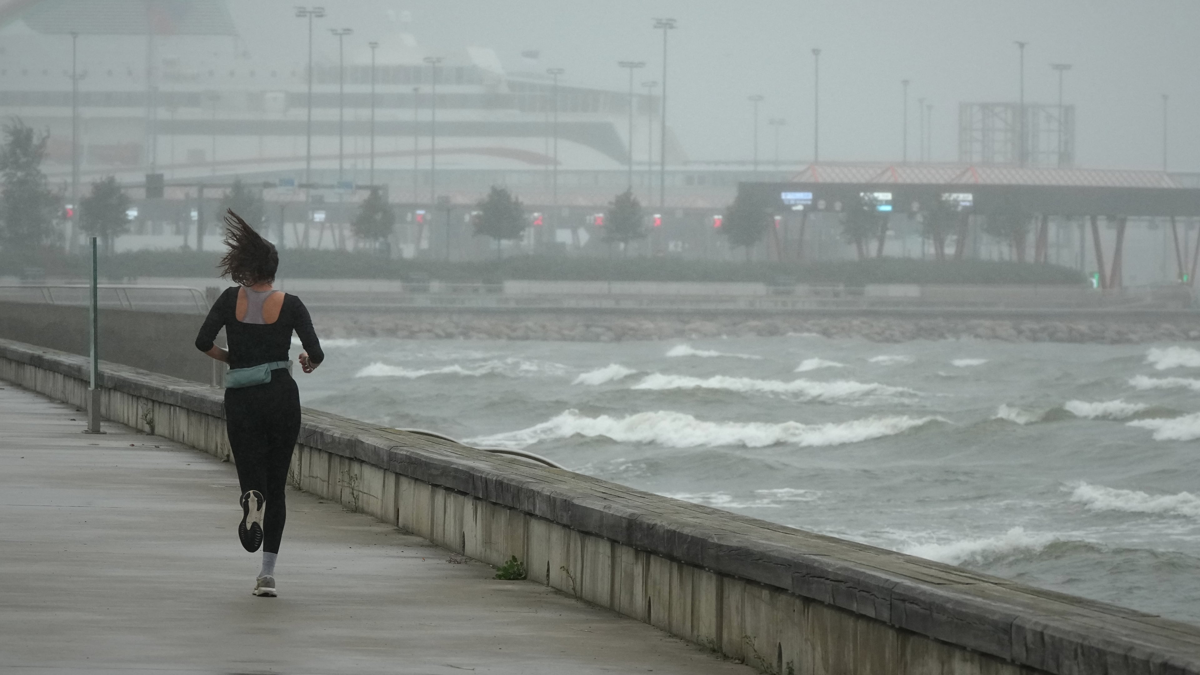 A jogger runs at the beach along the Tallinn bay of the Baltic sea on a rainy and windy day in Tallinn, Estonia, Sunday, Aug. 23, 2026. (AP Photo/Sergei Grits)