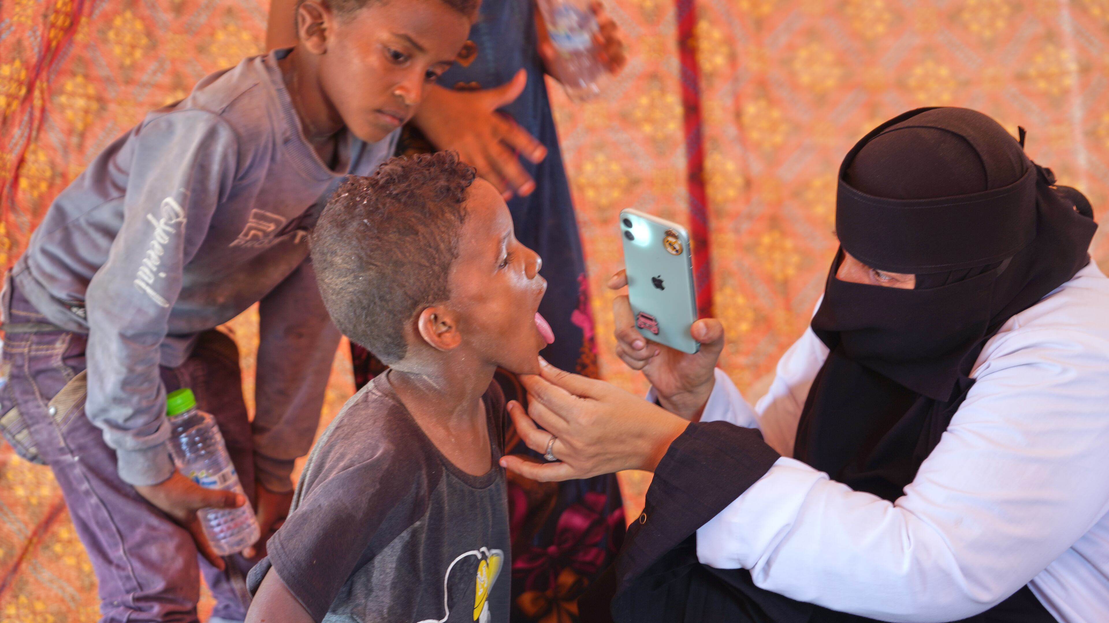 A doctor examines a displaced child at Al-Firdaws camp in Ras Imran, just outside Aden, Yemen, Monday, Sept. 14, 2026. (AP Photo/Abdulnasser Alseddik)