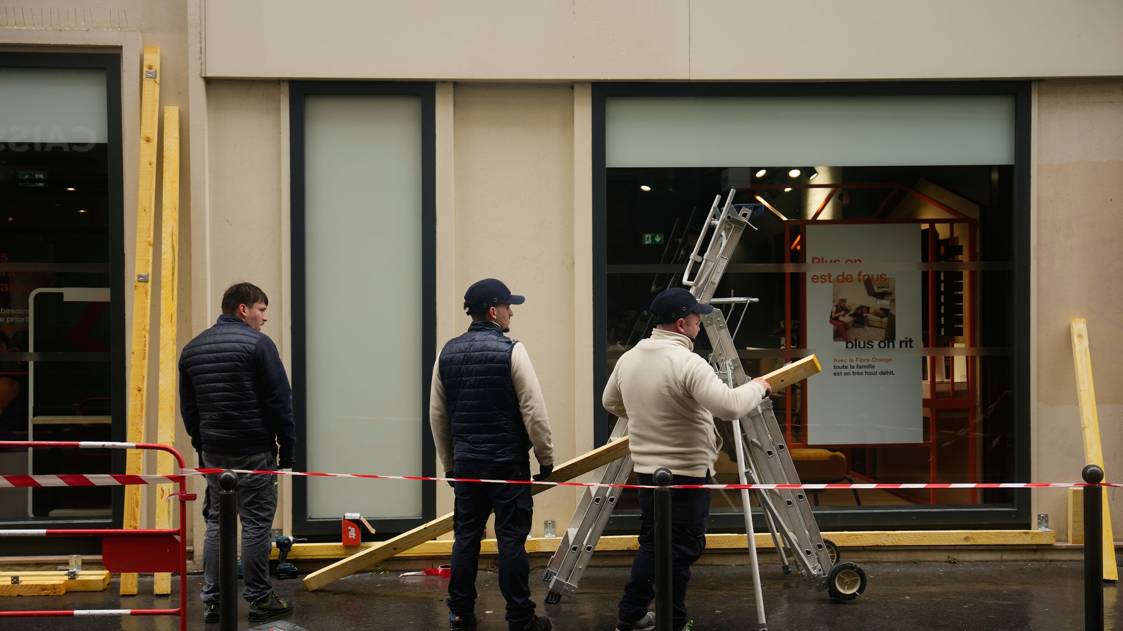Workers board up a storefront on the eve of a demonstration against rising living costs in Paris, Friday, Oct. 23, 2026. (AP Photo/Teresa Suarez)