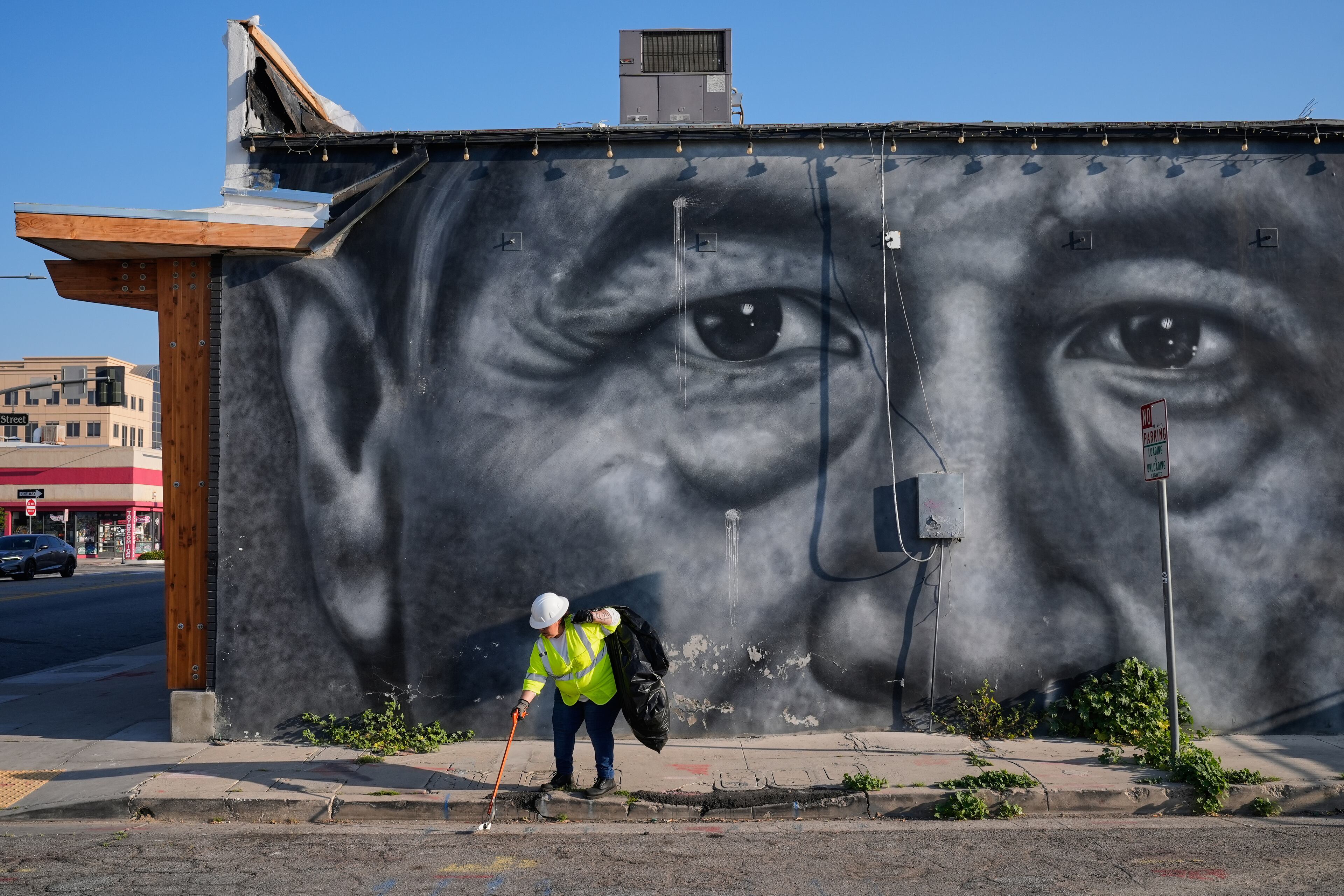 A sanitation worker picks up trash next to a mural of César Chavez in Bakersfield, Calif., Thursday, March 19, 2026. (Godofredo A. Vásquez/AP)