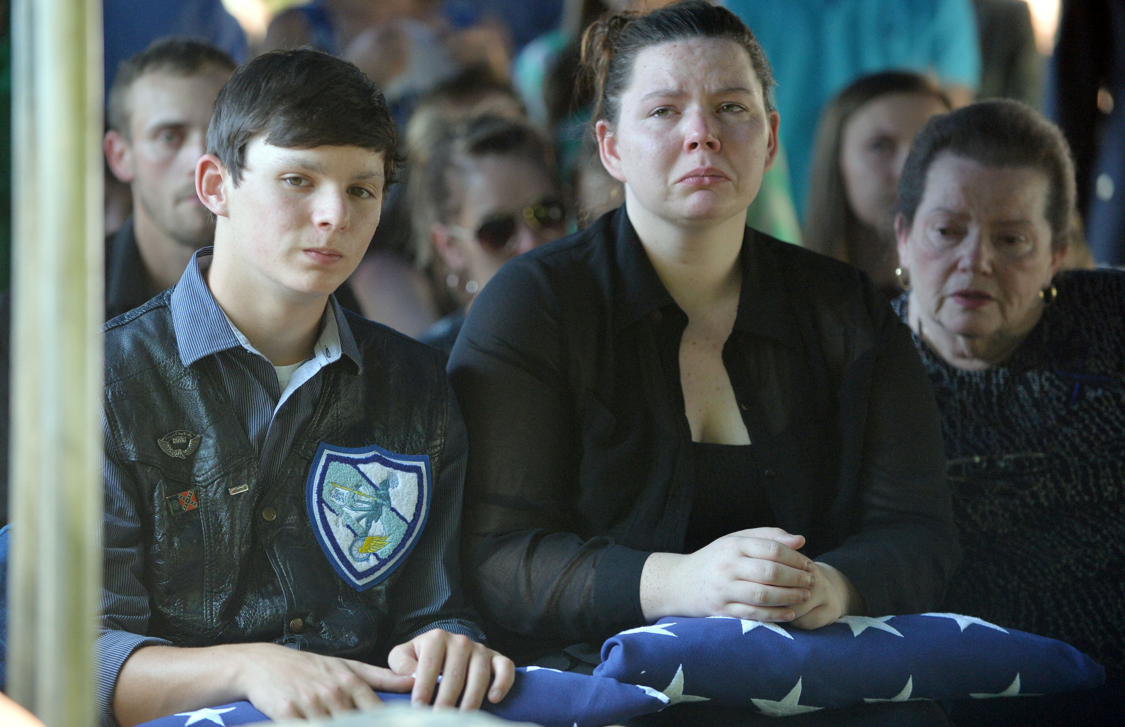 Zachary Hawk and Victoria Hawk, son and daughter of police officer Noel Lee Hawk, are presented the flag by Eatonton Police Chief Kent Lawrence. Officer Hawk suffered a fatal heart attack shortly after breaking up a fight between a juvenile and an adult at an Eatonton fast-food restaurant on May 4.
