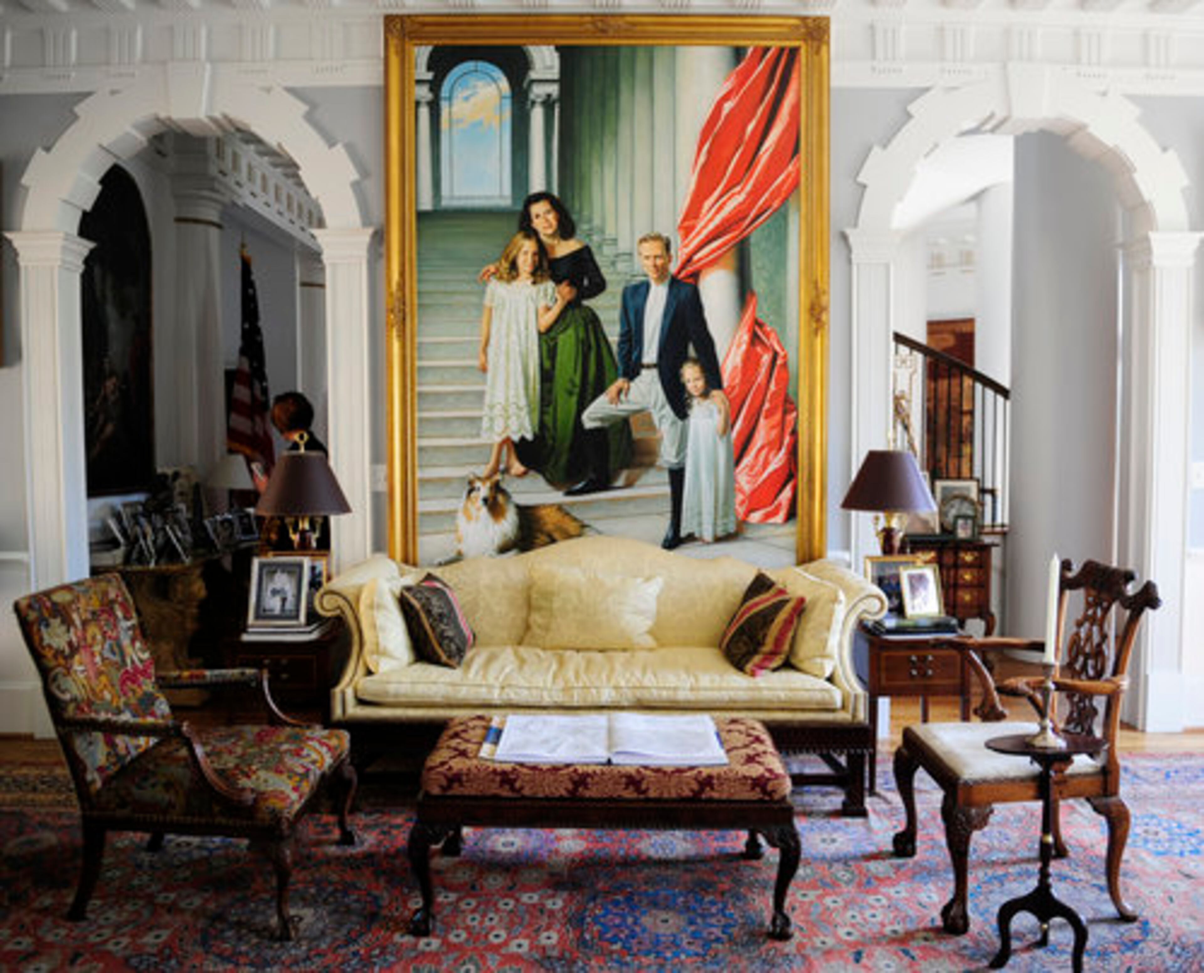 The arched doorway behind the Cook family in this portrait matches those on either side of the wall where it is displayed. With its repeating columns and climbing stairs, the portrait surrounds the family appropriately amid a classical motif.