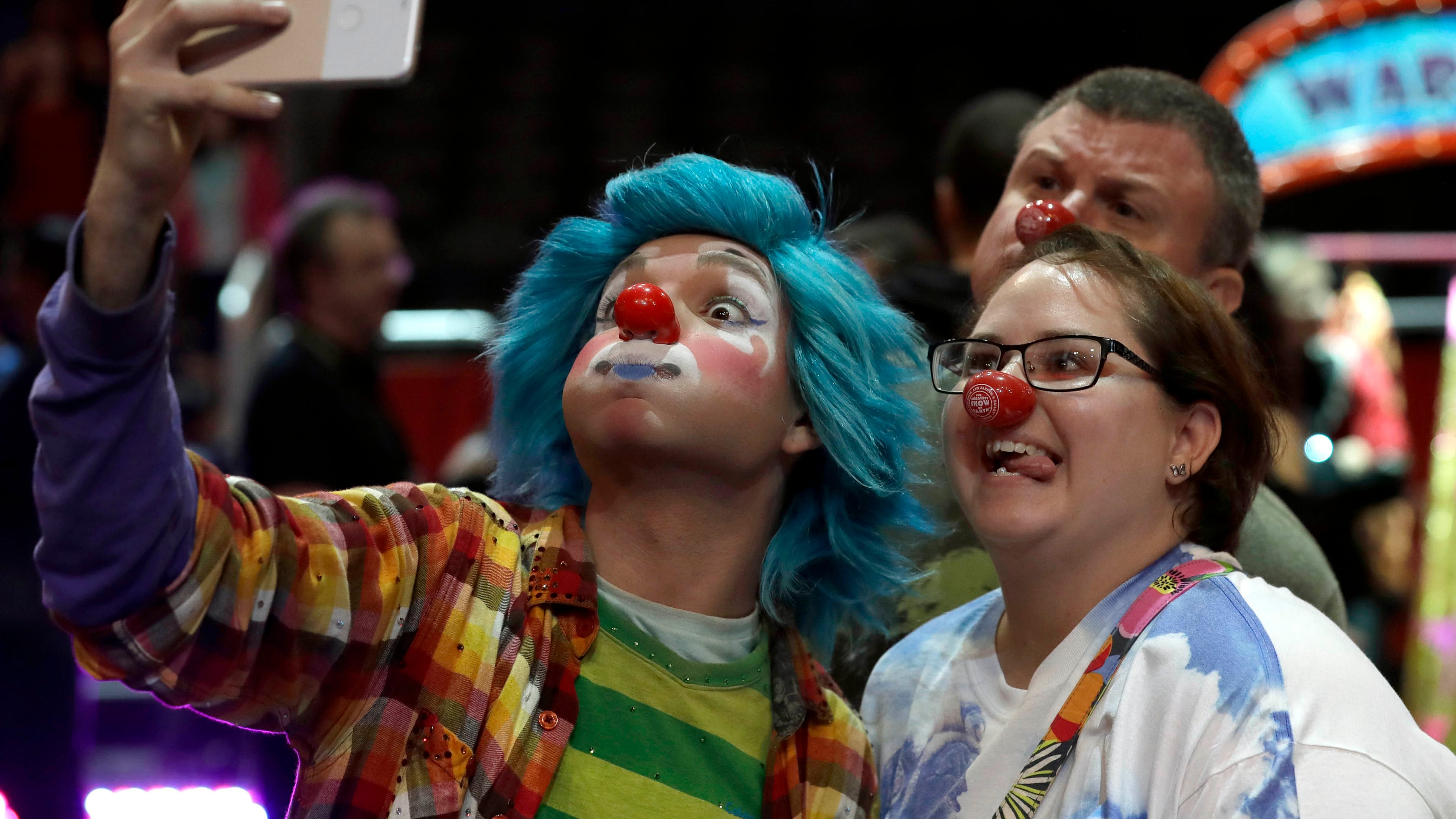 A Ringling Bros. and Barnum & Bailey clown takes a selfie with Jennifer and Kevin Fox, of Fort Pierce, Fla., during a pre show for fans Saturday, Jan. 14, 2017, in Orlando, Fla. The Ringling Bros. and Barnum & Bailey Circus will end the "The Greatest Show on Earth" in May, following a 146-year run of performances. Kenneth Feld, the chairman and CEO of Feld Entertainment, which owns the circus, told The Associated Press, declining attendance combined with high operating costs are among the reasons for closing. (AP Photo/Chris O'Meara)