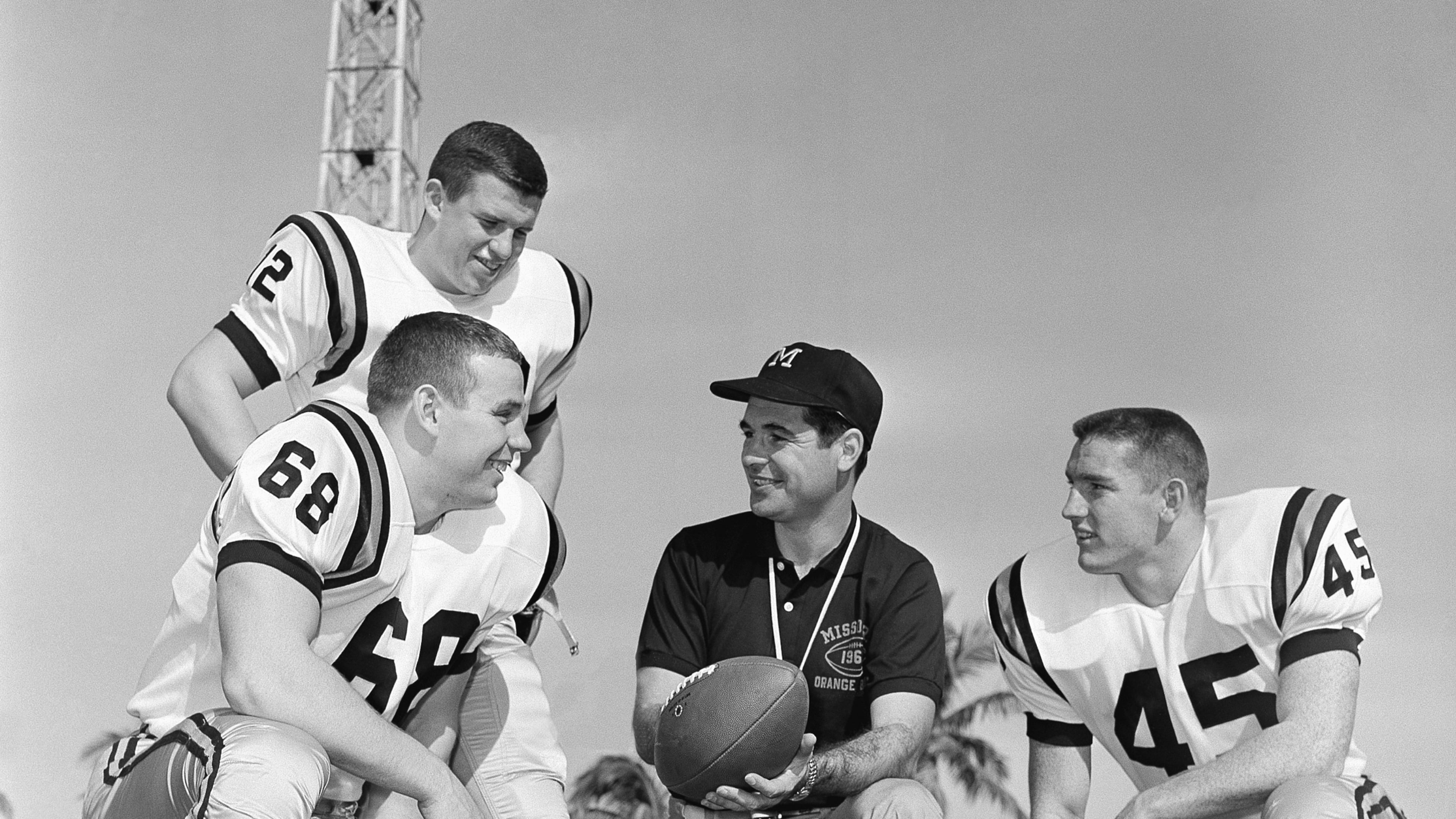 FILE - Missouri head coach Dan Devine, center, meets with three of his girders, Paul Henley (68), guard; Ron Tayler (12), quarterback; and Donnie Smith (45), halfback, in Miami on Dec. 27, 1960. (AP Photo/Earl Shugars, File)