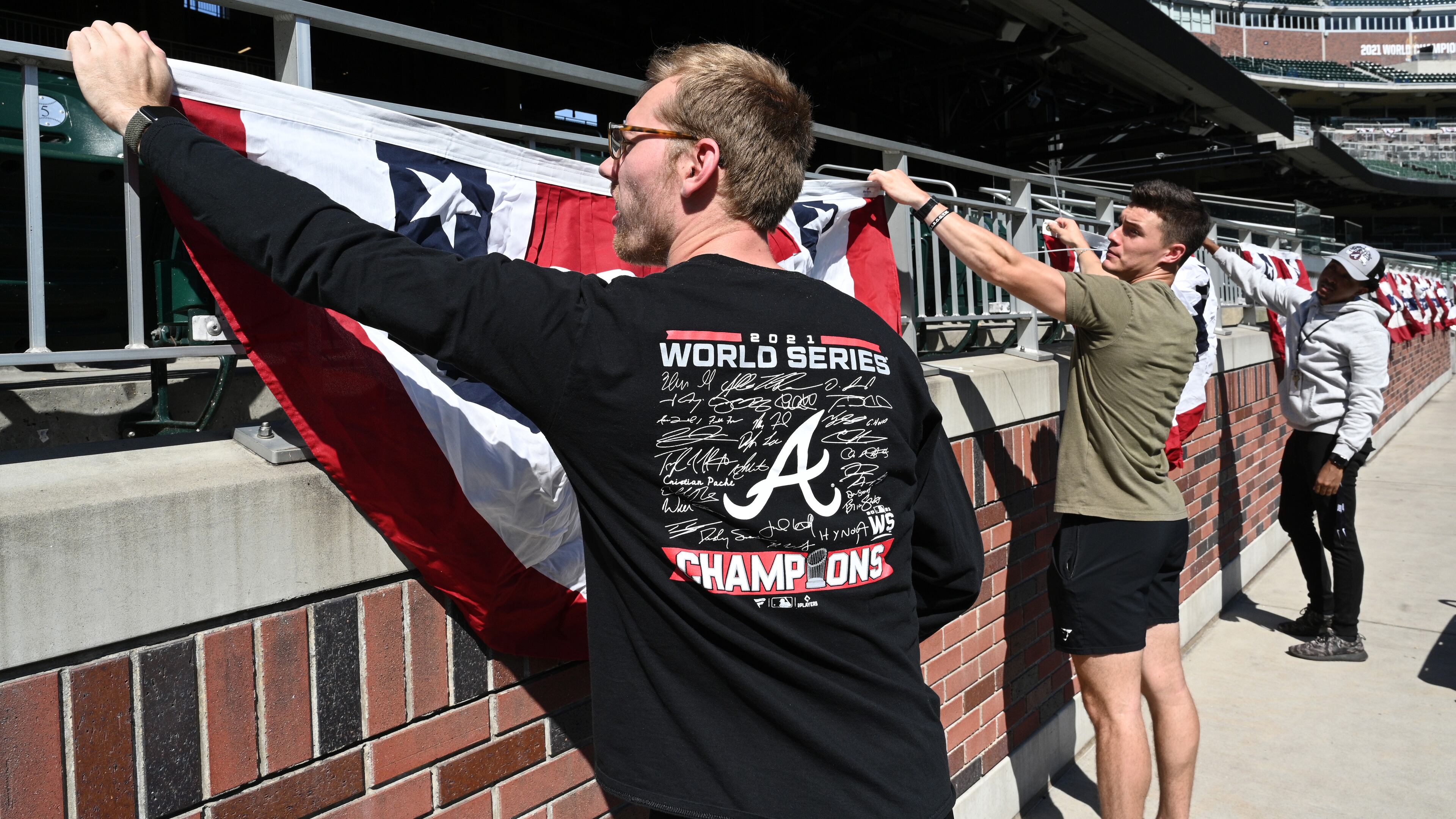 October 7, 2022 Atlanta - From left, Evan Foertsch, Bruce Stephens and Clayton Rounsaville install flag buntings prior to National League Division Series (NLDS) starting next Tuesday at Truist Park on Friday, October 7, 2022. (Hyosub Shin / Hyosub.Shin@ajc.com)