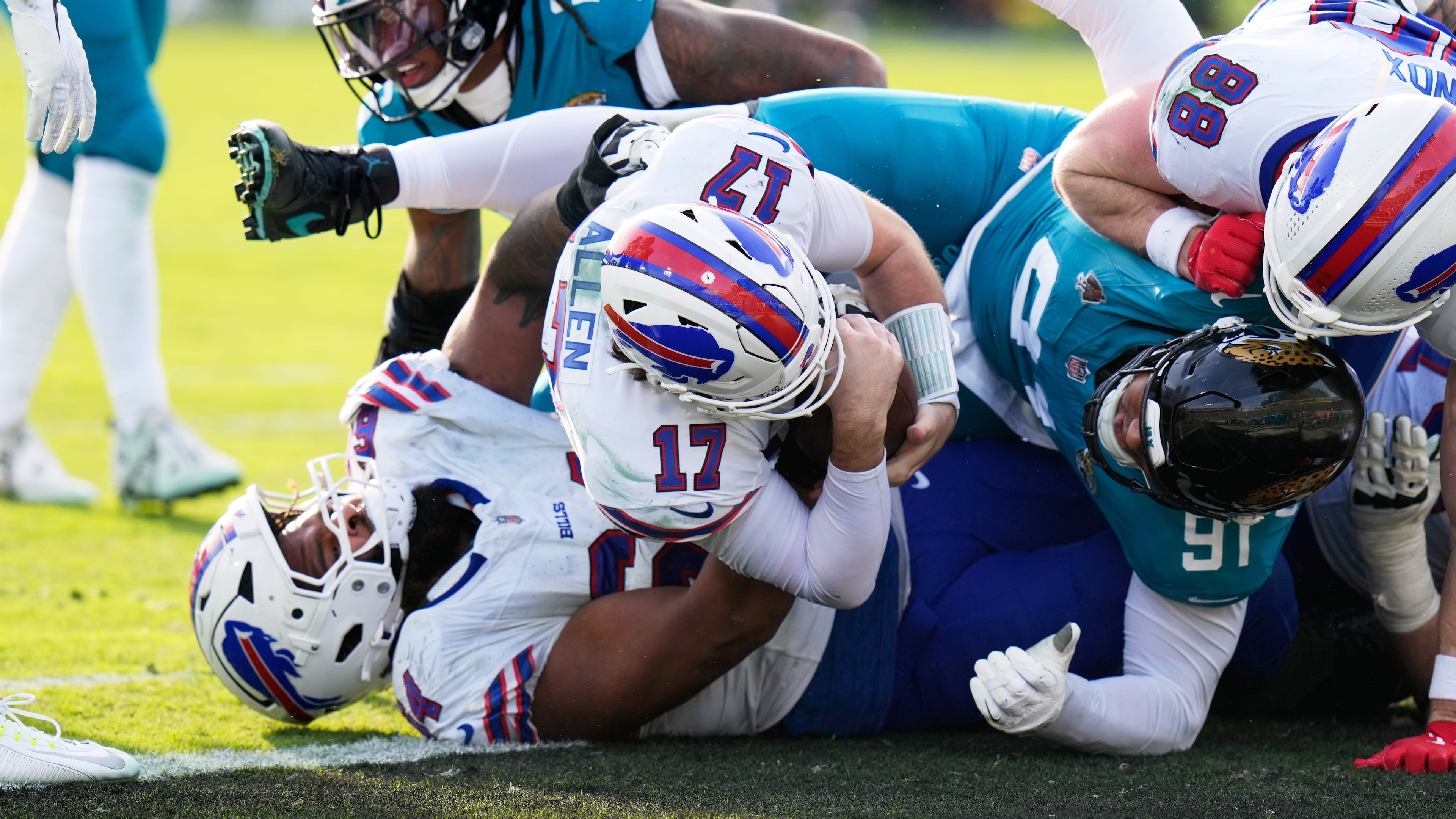 Buffalo Bills quarterback Josh Allen (17) pushes in for a first down as Jacksonville Jaguars defensive tackle Arik Armstead (91) tries to stop him during the second half of an NFL wild-card playoff football game Sunday, Jan. 11, 2026, in Jacksonville, Fla. (AP Photo/Chris O'Meara)