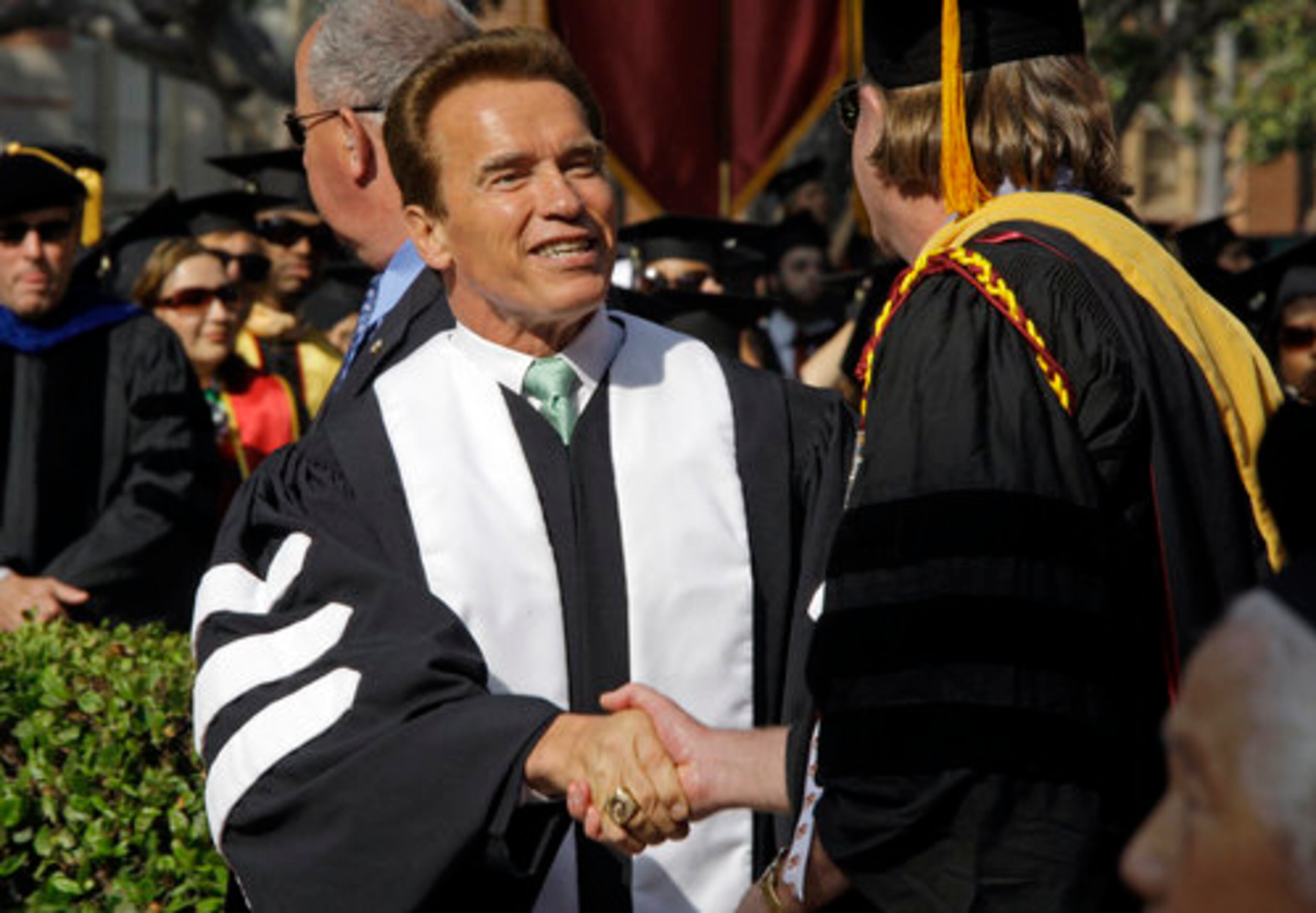 California Gov. Arnold Schwarzenegger greets a faculty member as he arrives to give the commencement address and receive a Doctor of Humane Letters honorary degree at the University of Southern California.
