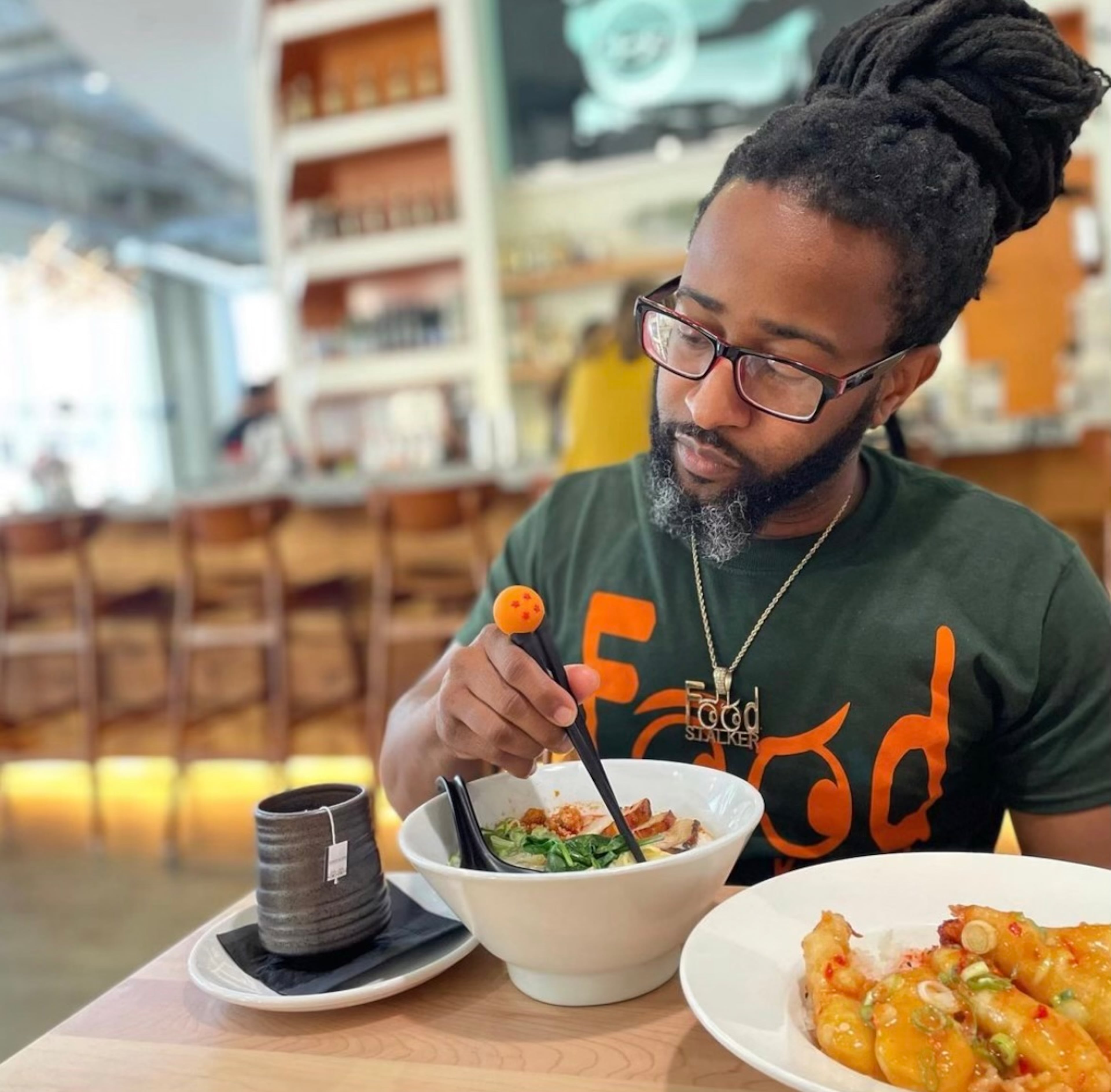 Justin Brown eating the E Ramen + signature ramen (center). Also shown is shrimp saku-saku. (Justin Brown for the AJC)