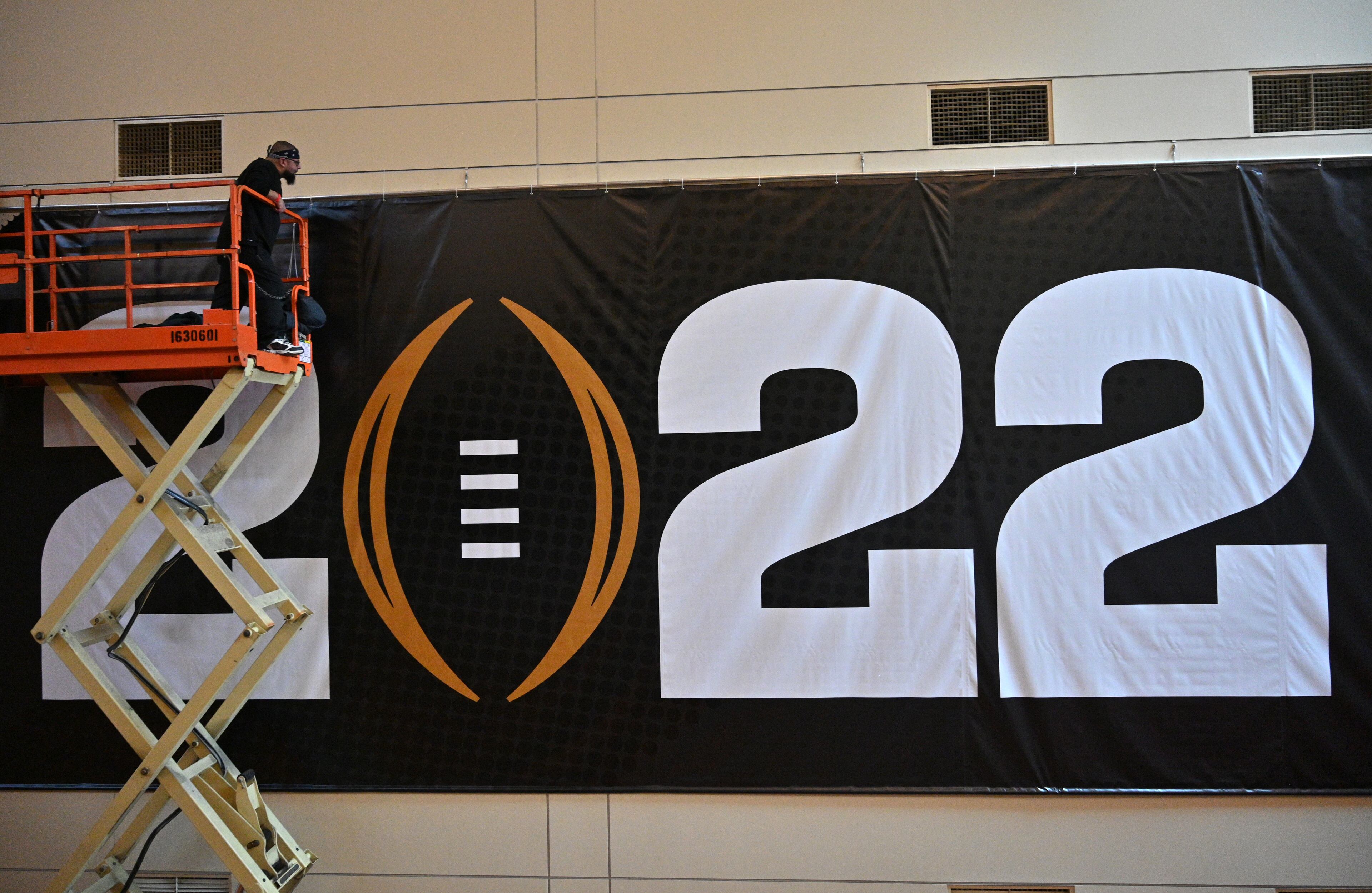 January 6, 2022 Indianapolis, IN - Workers put up signages inside the Indiana Convention Center, where Playoff Fan Central will take place as a part of the College Football Playoff National Championship in Indianapolis on Thursday, January 6, 2022. (Hyosub Shin / Hyosub.Shin@ajc.com)