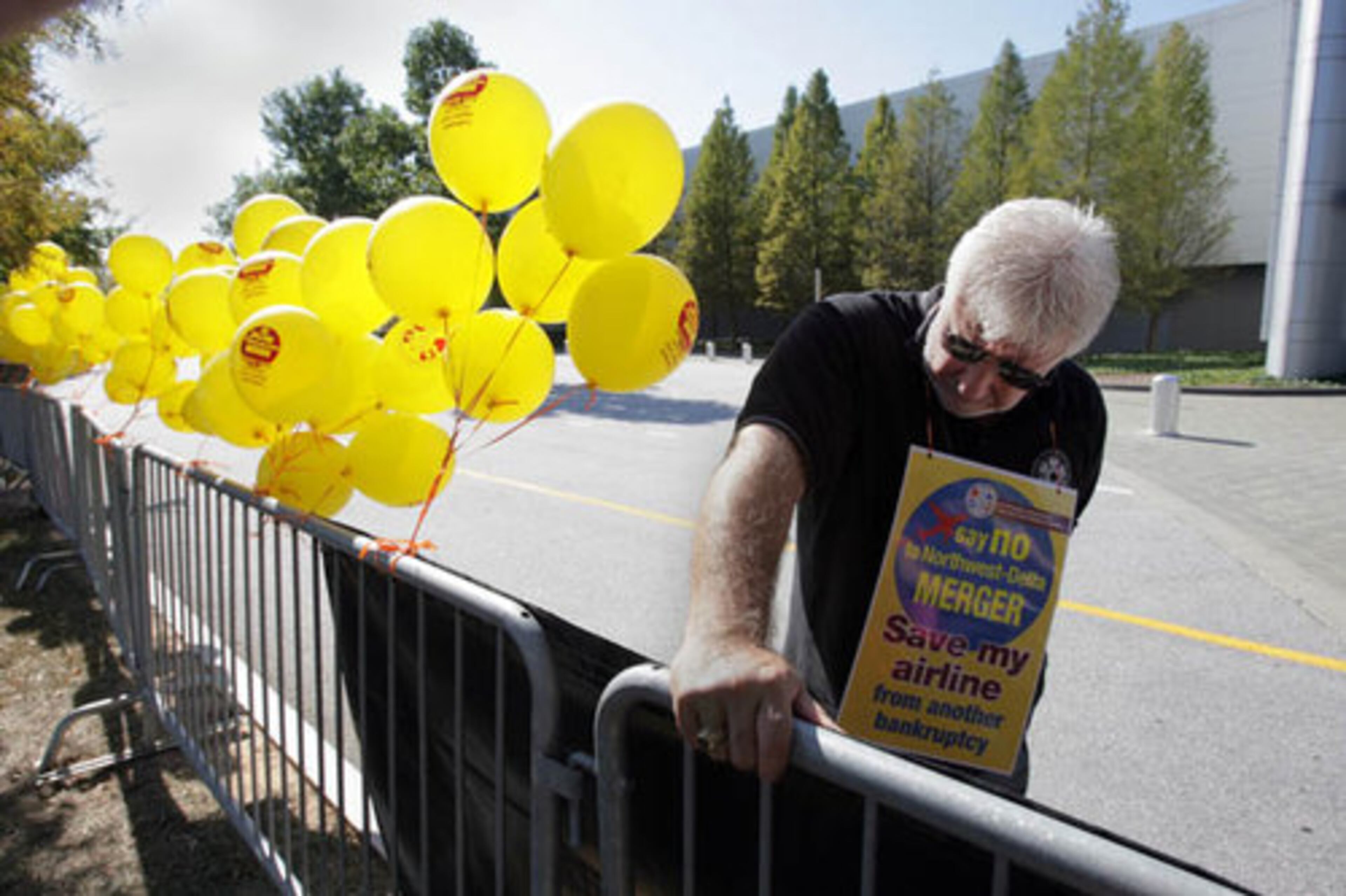 Al Wojcik, an organizer with the International Association of Machinists and Aerospace Workers, stands in front of the Georgia International Convention Center in College Park to urge Delta shareholders to vote against the merger.