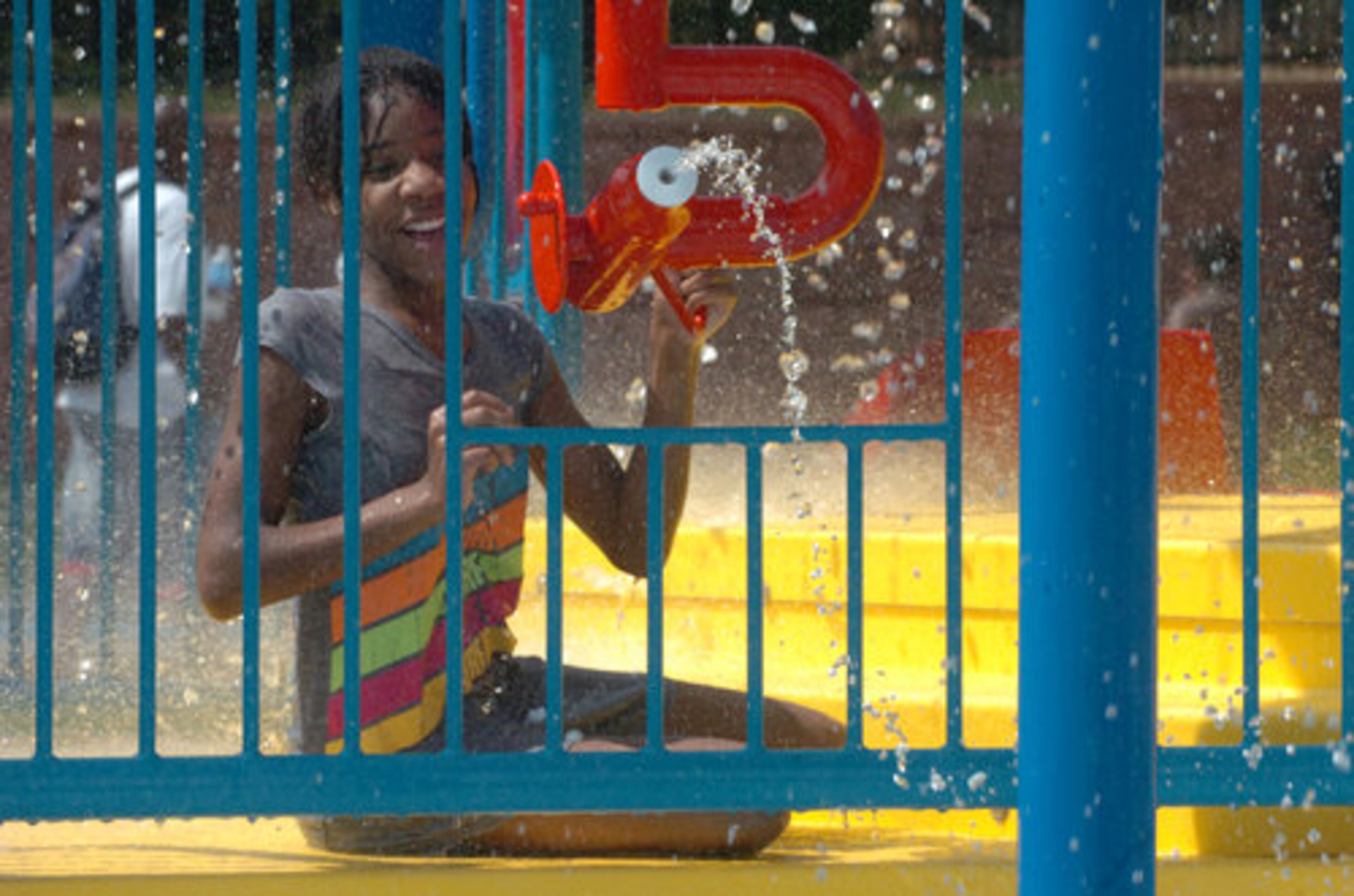 Alasia Melvin, 11, sprays water on friends below her water gun emplacement.