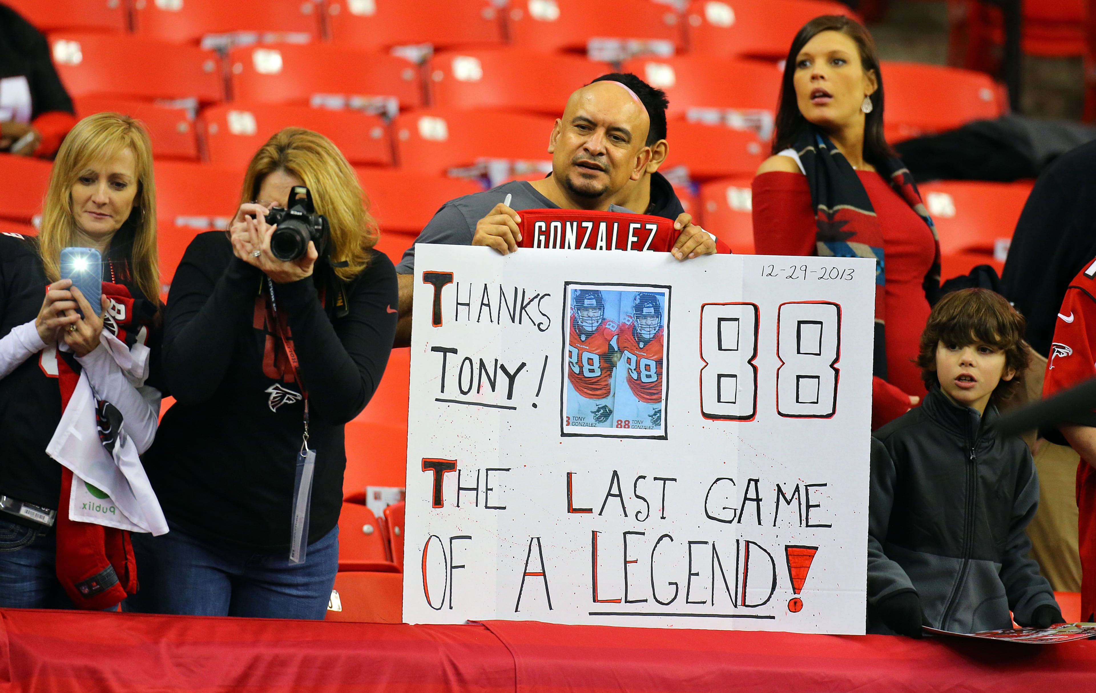 Jaime Martinez, Buford, holds his "Last Game of a Legend" sign as Falcons tight end Tony Gonzalez takes the field to warmup for the final game of his 17-year NFL career on Sunday, Dec. 29, 2013, in Atlanta. Gonzalez stopped on his way off the field and autographed the sign for Martinez.