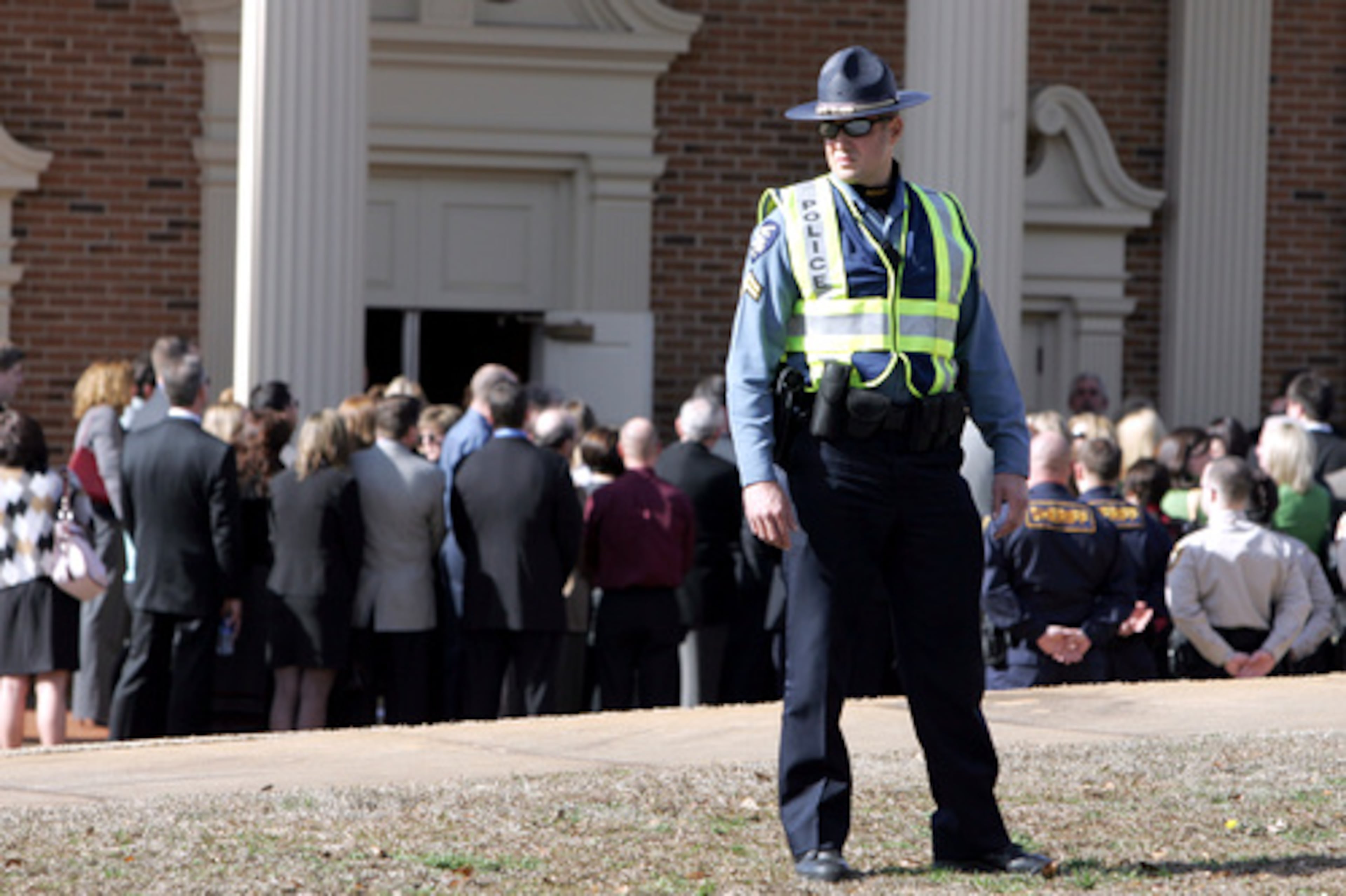 A police officer directs traffic outside the church.