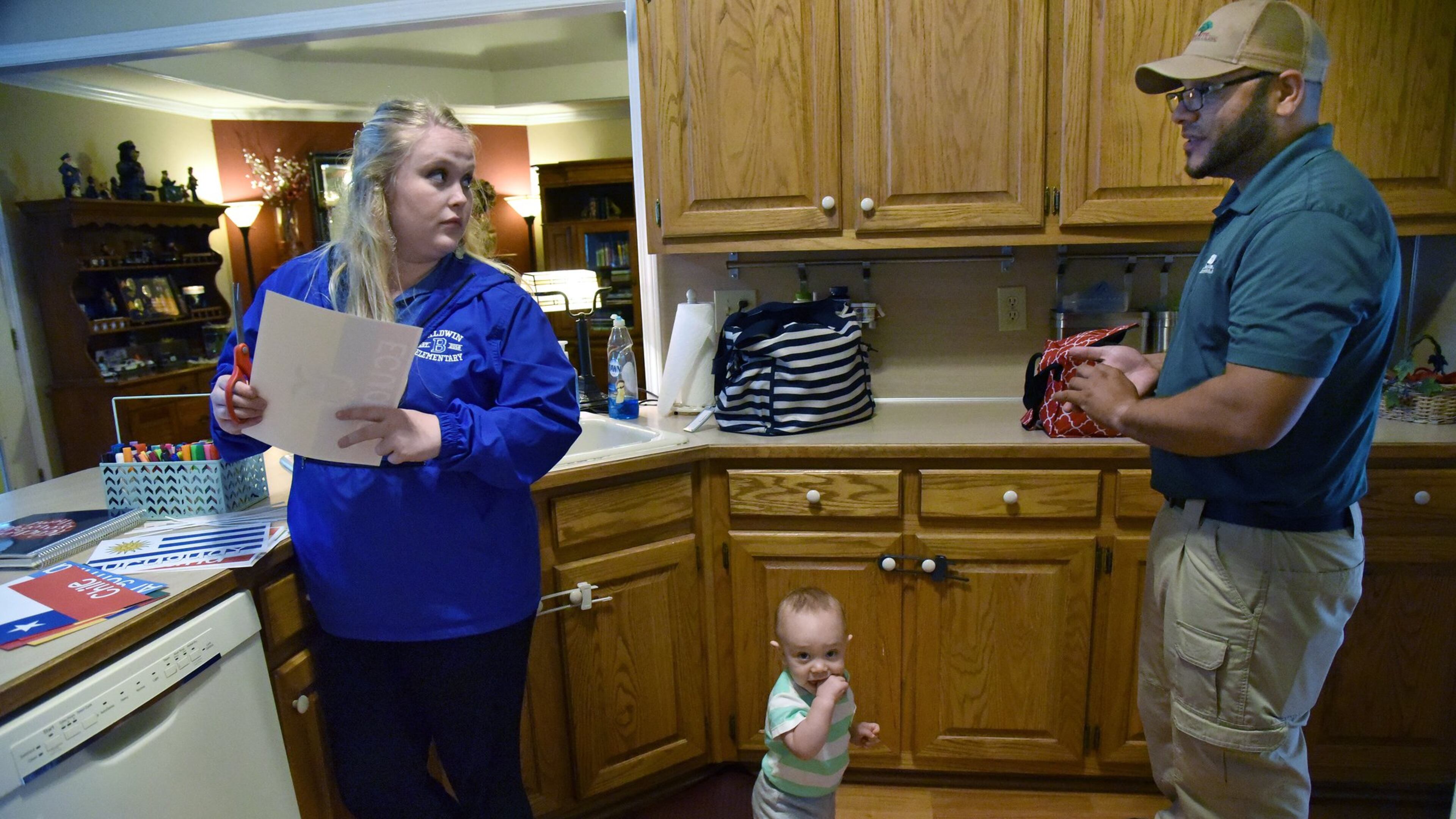 Audrey Smith cuts out some of her teaching materials as Jose Velez looks after their 11-month-old son Timothy at their home in Dacula on Friday, May 5. On the first day of this school year, first-year teacher Audrey Smith let us shadow her through that day, which included learning the names of her students, attempting to teach them how to behave and nearly forgetting to get one student on the school bus at the end of the day. As the school year ends, we check in with Smith, who has learned a lot about the teaching profession, parenting and herself by being a teacher. She quickly learned one big reason why teachers leave the profession: money. Smith, mother of a newborn son, lives with her parents and her boyfriend. Without her family’s financial support, Smith says she wouldn’t make it as a teacher. HYOSUB SHIN / HSHIN@AJC.COM