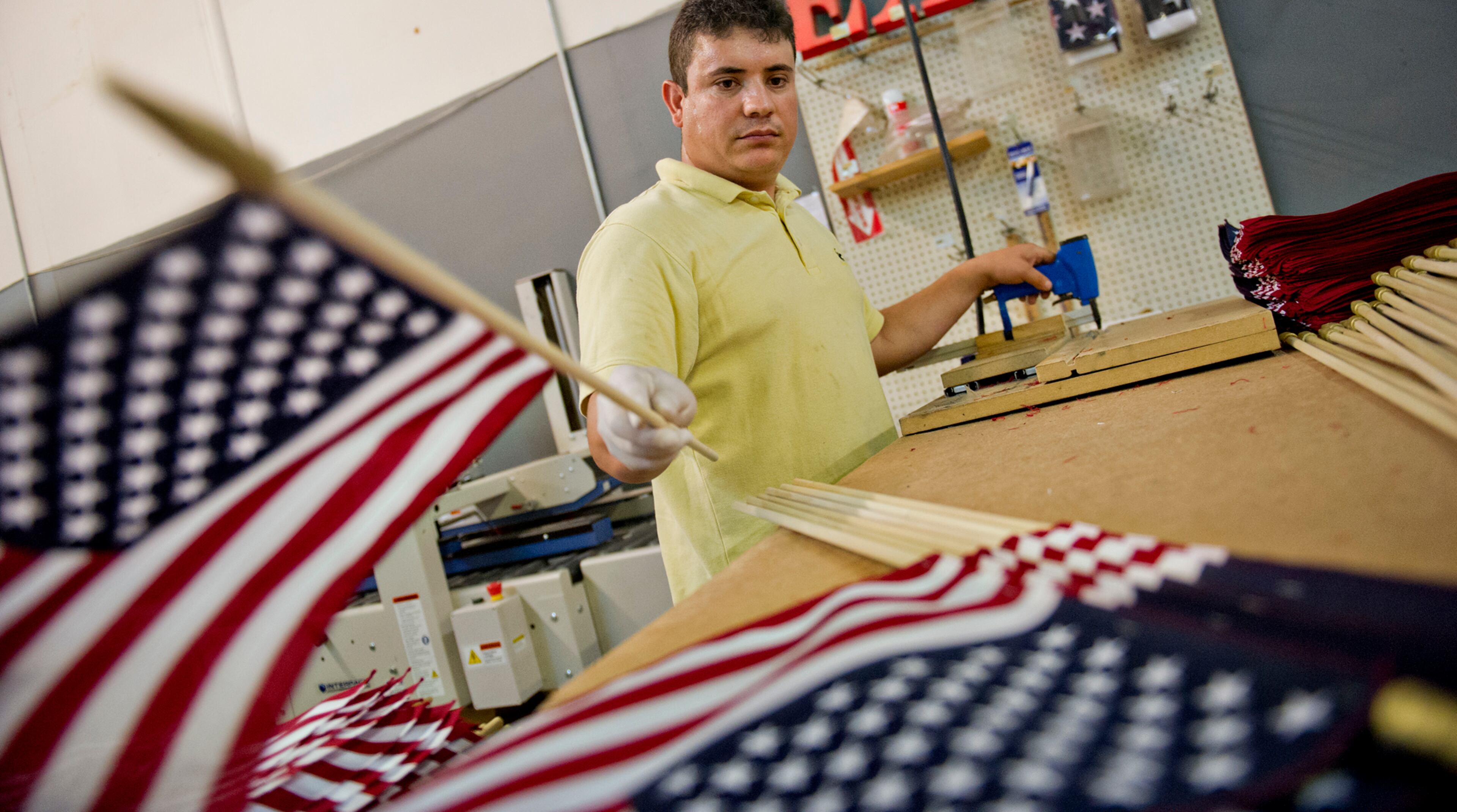 Rosendo Flores places an American flag into a pile at U.S. Flag Makers in Marietta on Wednesday, July 2, 2014. JONATHAN PHILLIPS / SPECIAL