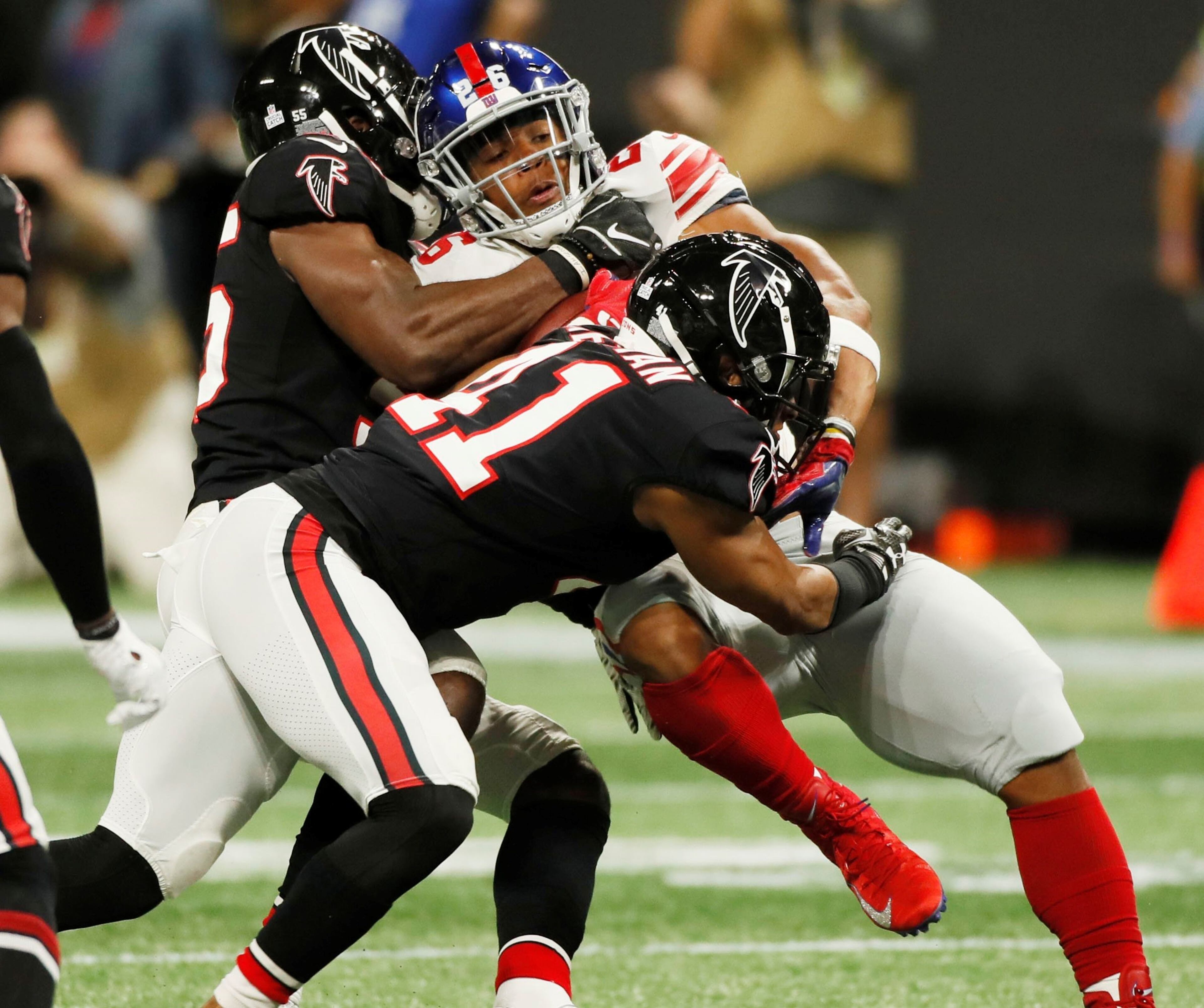 10/22/18 - Atlanta -Atlanta Falcons linebacker Bruce Carter (55) and Atlanta Falcons defensive back Sharrod Neasman (41) put the stop New York Giants running back Saquon Barkley (26) in the first half. The Atlanta Falcons played the New York Giants in an NFL football game Monday, October 22, 2018, at Mercedes-Benz Stadium in Atlanta, GA. BOB ANDRES / BANDRES@AJC.COM
