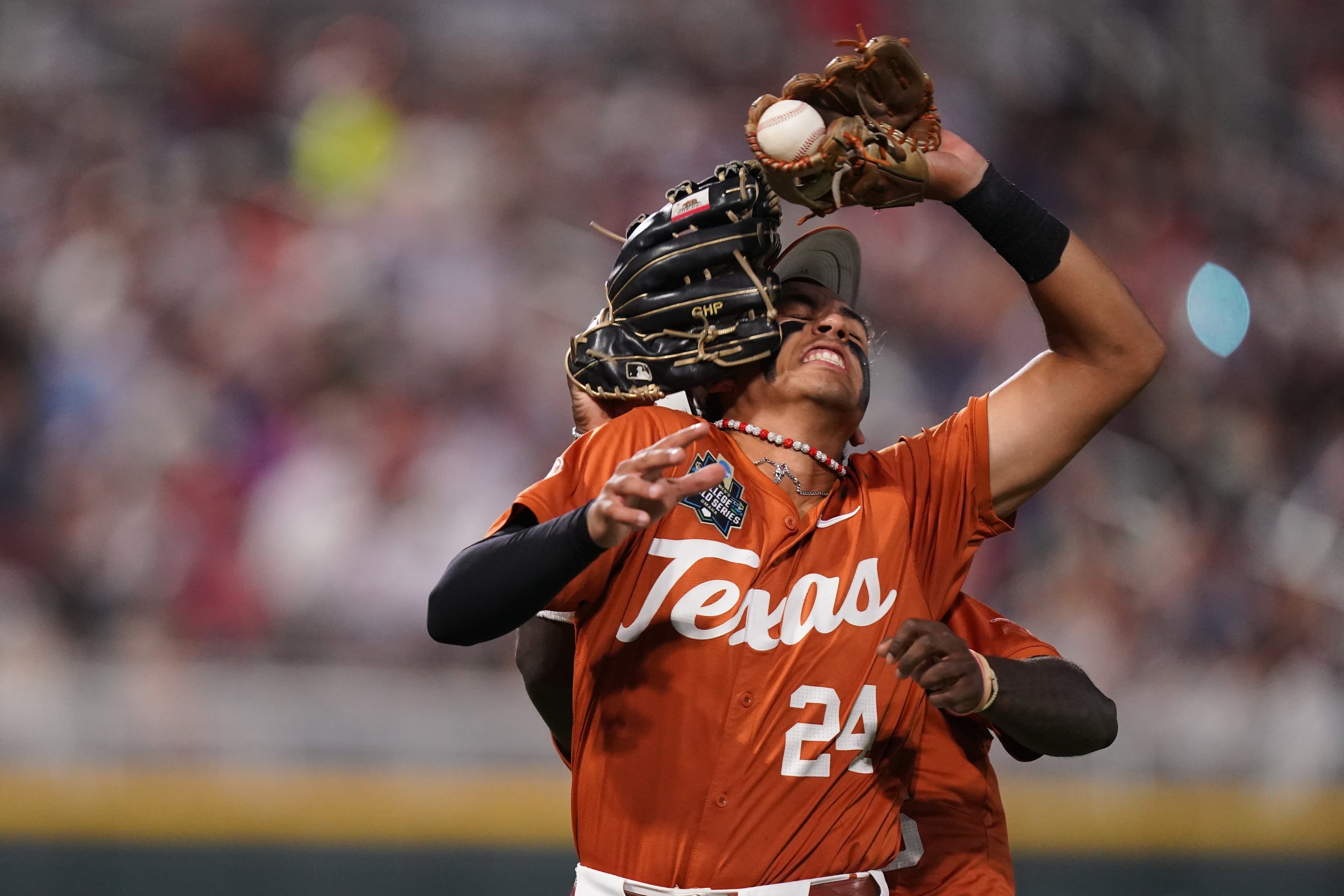 Texas infielder Adrian Rodriguez (24) makes the catch while colliding with outfielder Anthony Pack Jr. (6) during an NCAA baseball College World Series elimination game against Georgia, Tuesday, June 16, 2026 in Omaha, Neb. Georgia won 2-0. (AP Photo/Vera Nieuwenhuis)