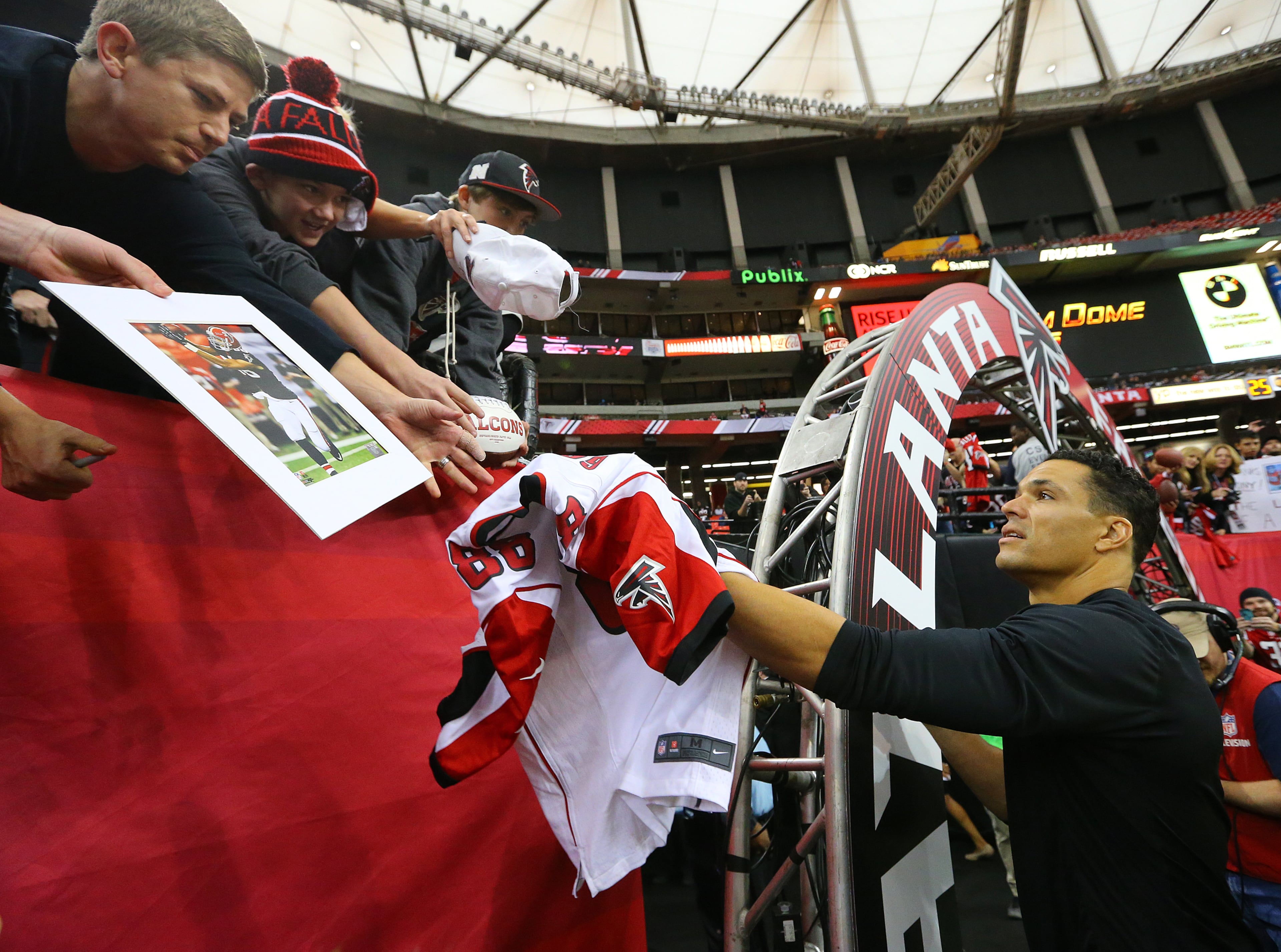 Falcons tight end Tony Gonzalez signs autographs for fans as he prepares to play the final game of his 17-year NFL career on Sunday, Dec. 29, 2013, in Atlanta.