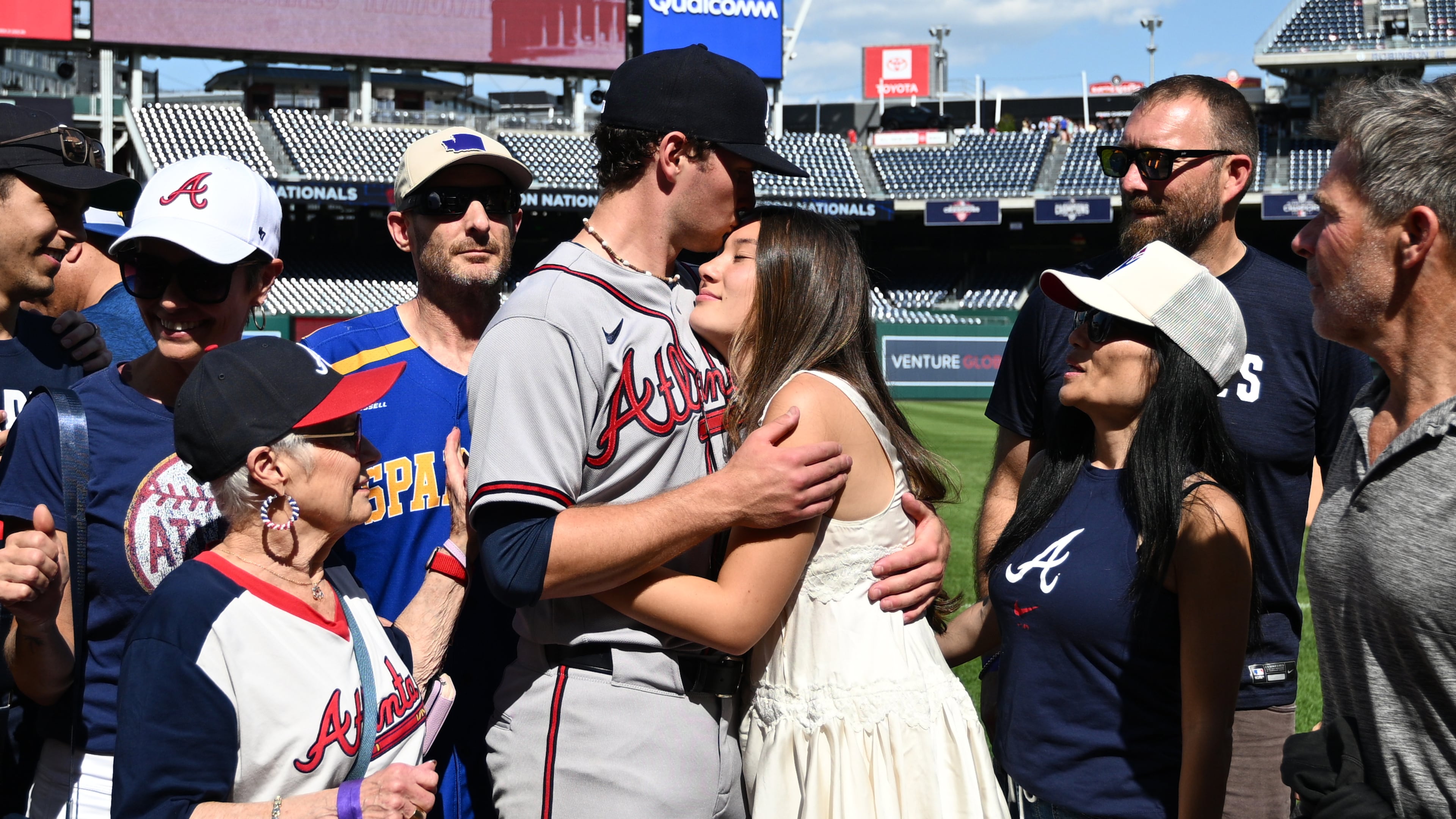 Atlanta Braves starting pitcher JR Ritchie, left center, hugs his fiancée Makena Miller after winning his major league debut baseball game against the Washington Nationals, Thursday, April 23, 2026, in Washington. (AP Photo/Nick Wass)