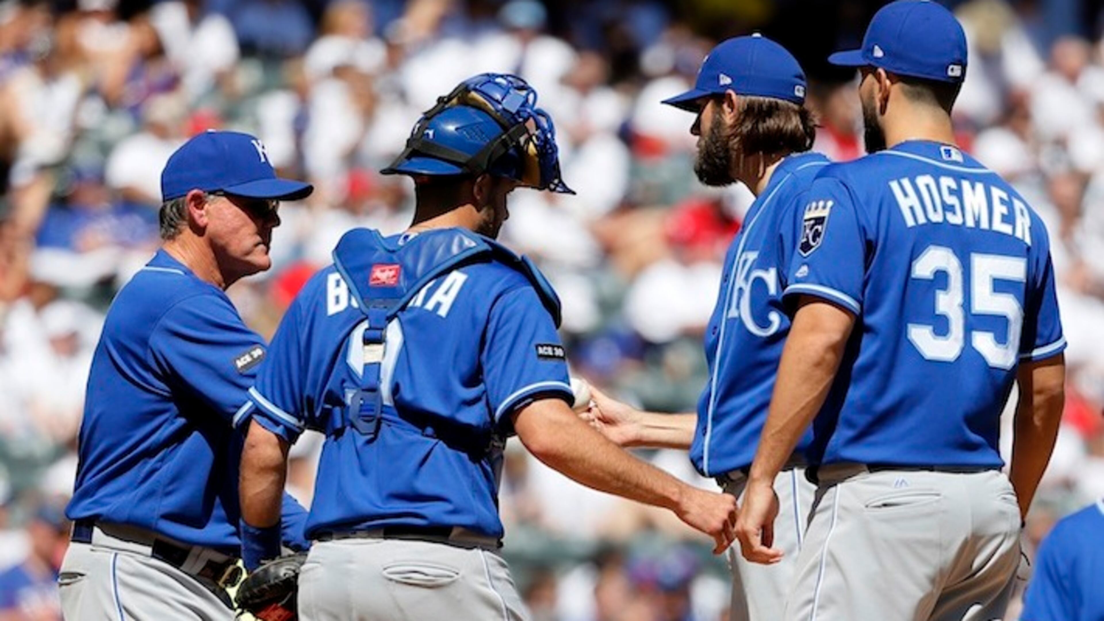 Kansas City Royals manager Ned Yost, left, takes the ball from starting pitcher Jason Hammel, right rear, in the fourth inning of a baseball game against the Texas Rangers as Drew Butera (9) and Eric Hosmer (35) stand on the mound in Arlington, Texas, Sunday, April 23, 2017. (AP Photo/Tony Gutierrez)