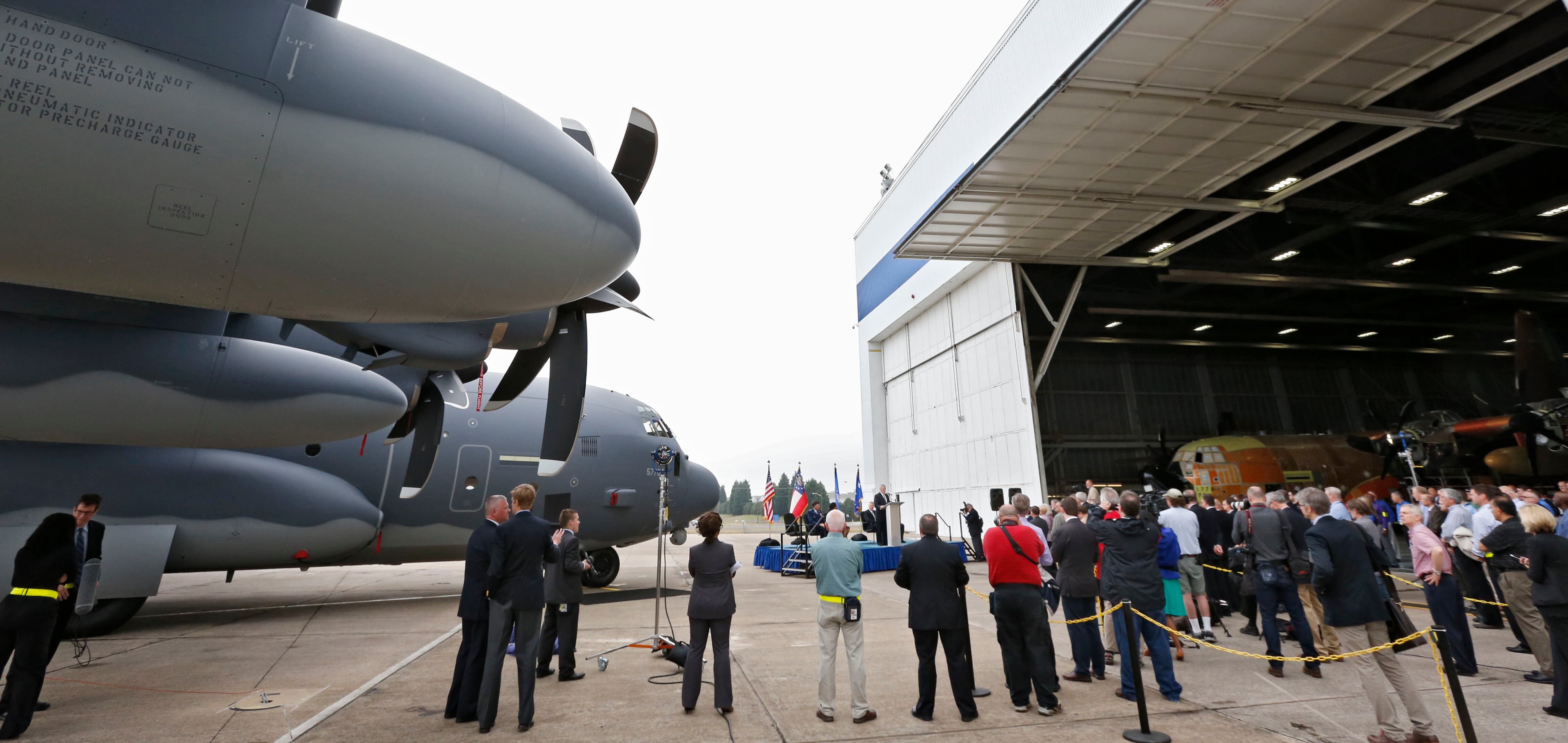 Gov. Nathan Deal (at podium in distance) commemorated the 60th anniversary on Tuesday, April 7, 2015, of the first flight of the first C-130 Hercules built at the Marietta production facility. He reenacted the 1955 christening, this time on a C-130J Super Hercules, using a bottle of Chattahoochee River water just as Gov. Marvin Griffin did 60 years ago. BOB ANDRES / BANDRES@AJC.COM