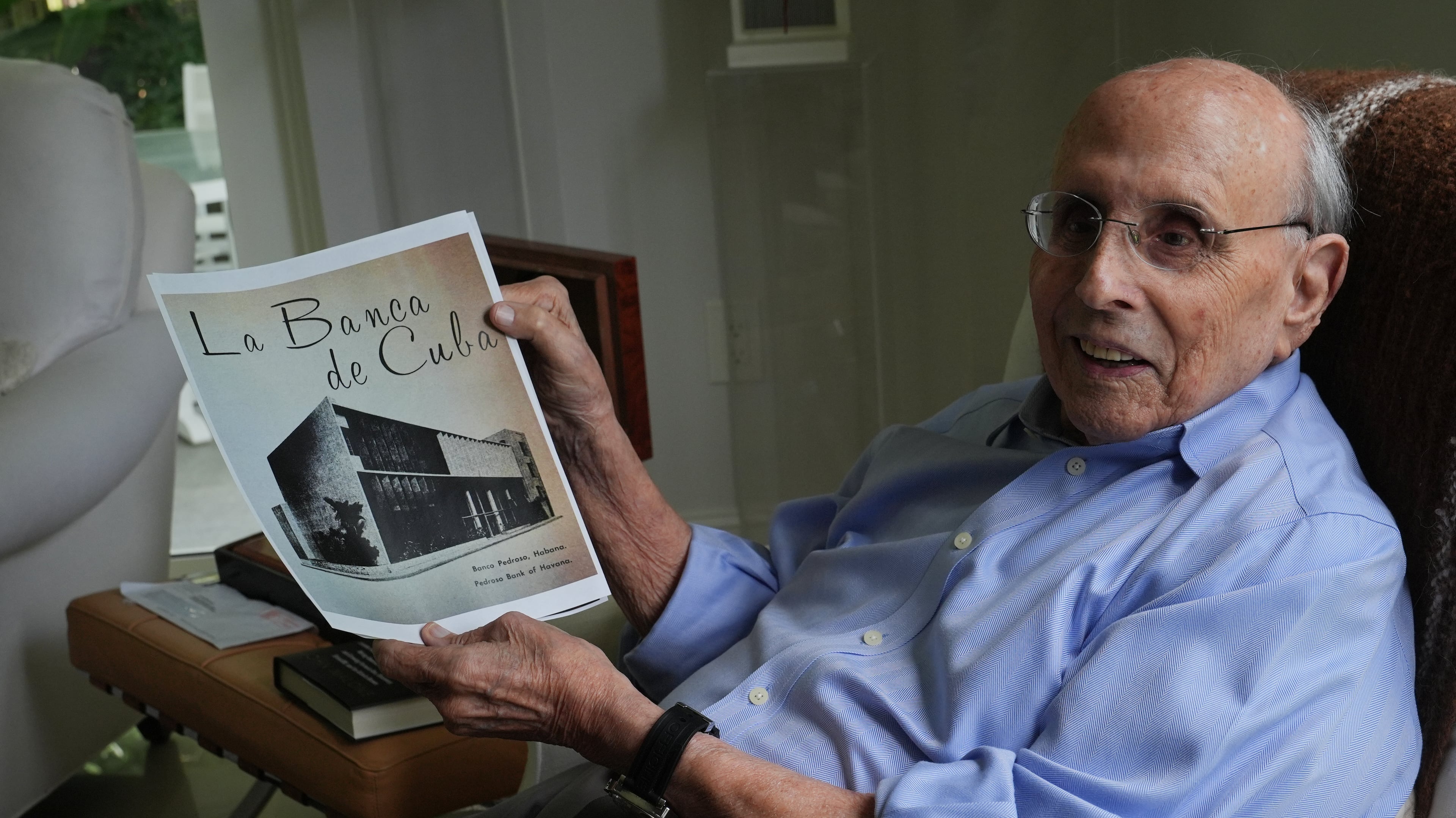 Raul Valdes-Fauli holds a picture of the family-owned Pedroso Bank in Havana during an interview Tuesday, April 21, 2026, in Coral Gables, Fla. (AP Photo/Marta Lavandier)