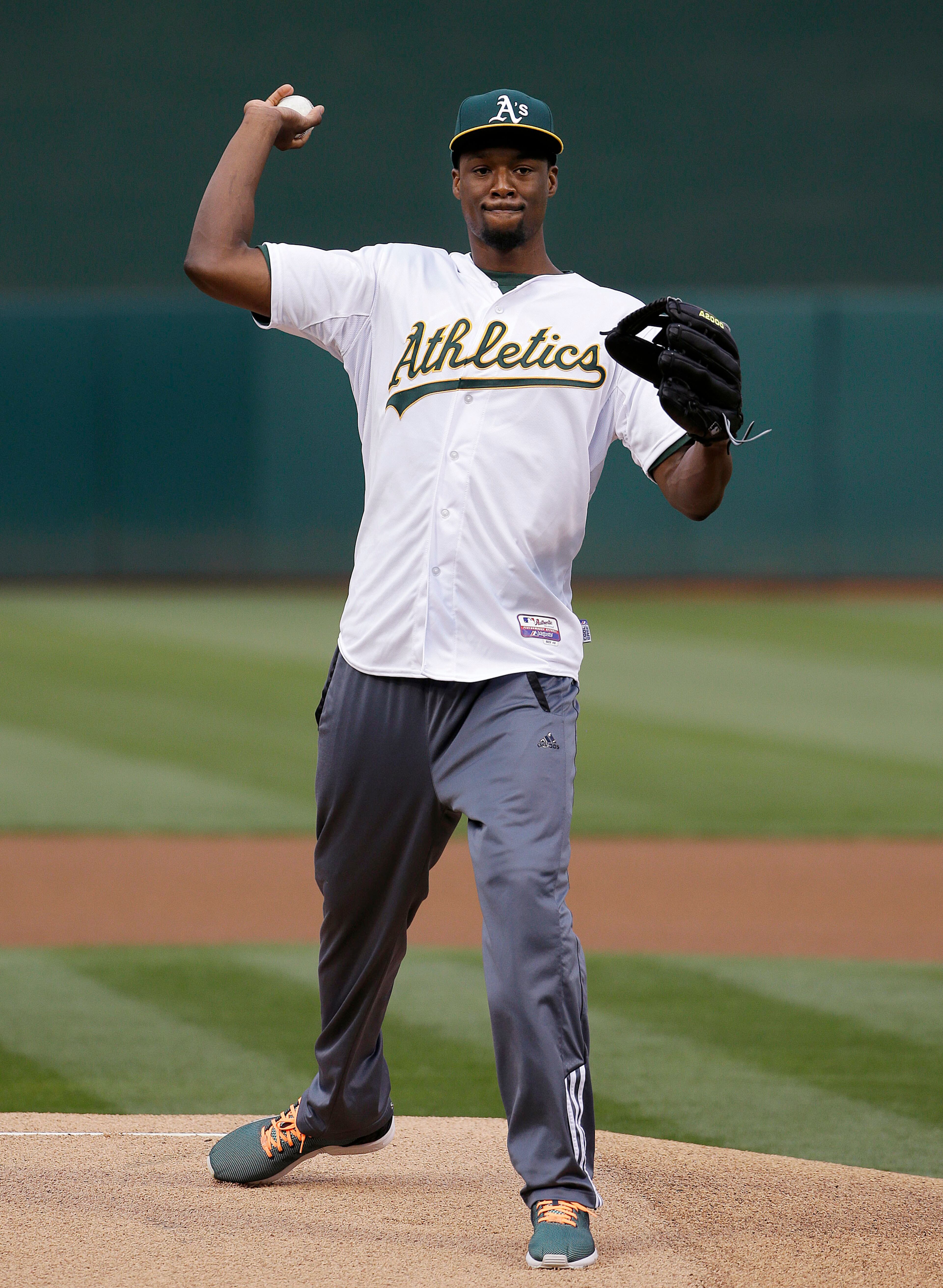 Golden State Warriors forward Harrison Barnes throws out the ceremonial first pitch before a baseball game between the Oakland Athletics and the Seattle Mariners in Oakland, Calif., Thursday, July 2, 2015. (AP Photo/Jeff Chiu)