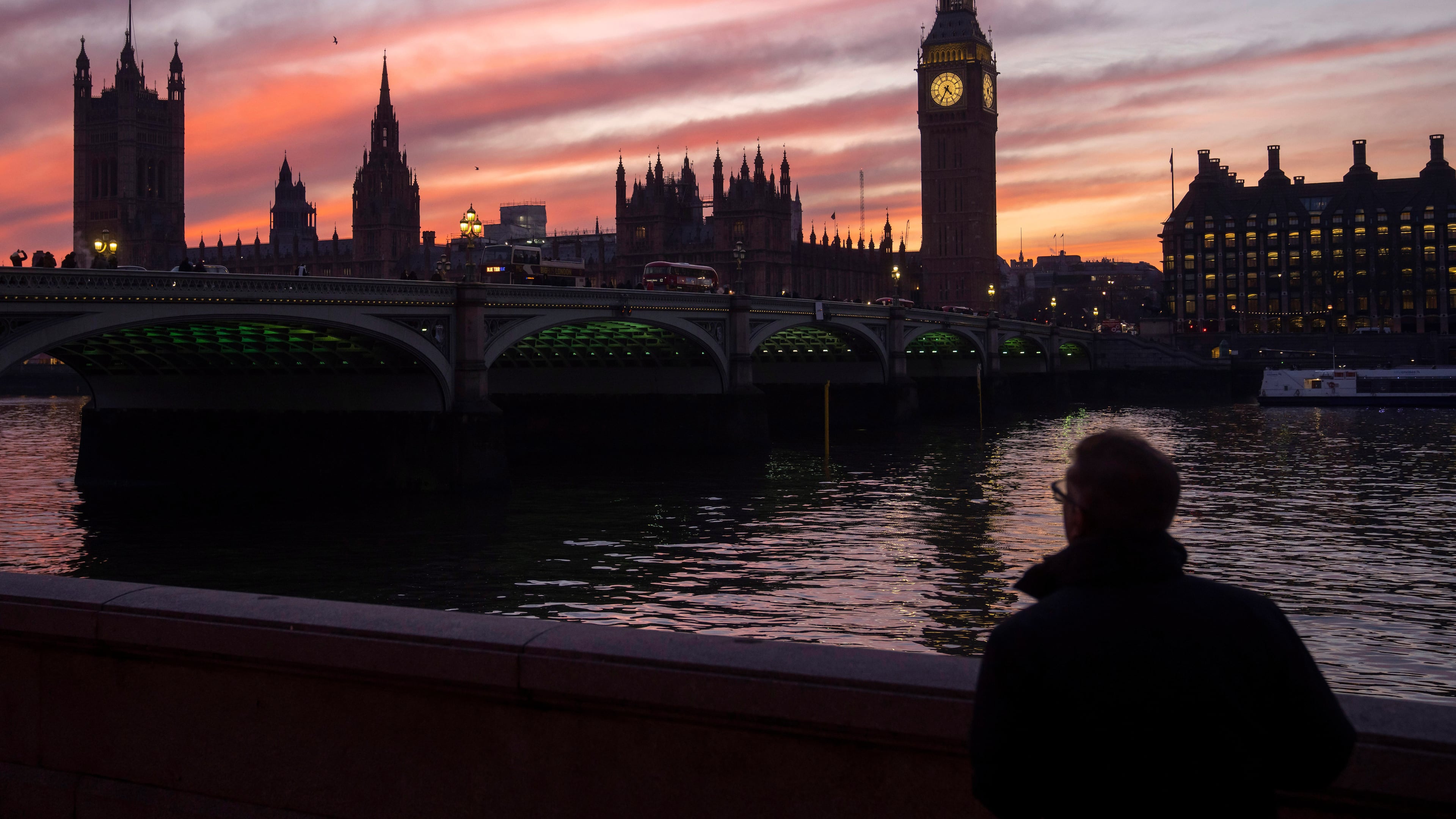 FILE - A man walks along the south bank of the River Thames backdropped by the Elizabeth Tower, known as Big Ben, of the Houses of Parliament, in London, Tuesday, Jan. 17, 2023. (AP Photo/Kin Cheung, File)
