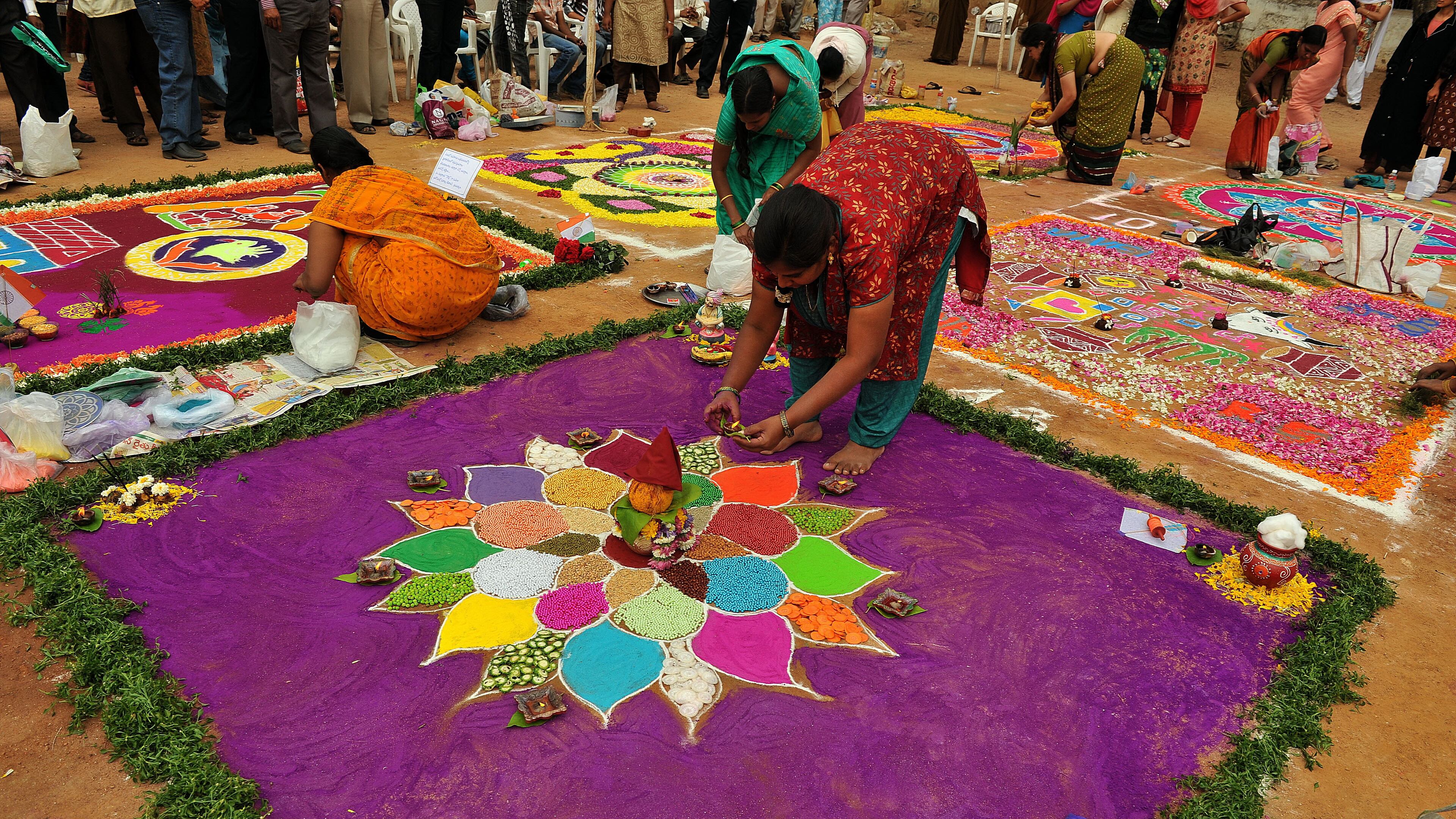 Indian women participate in a Rangoli competition (hindu ritual design) in Hyderabad, on January 11, 2012. Rangoli is a traditional decorative folk art from India. These are decorative designs made on floors of living rooms and courtyards are meant as sacred welcoming areas for the Hindu deities during Sankranthi festival is also known as the harvest festival and is celebrated on 14th January through the country and marks the transition from winter to spring. AFP PHOTO / Noah SEELAM (Photo credit should read NOAH SEELAM/AFP/Getty Images)