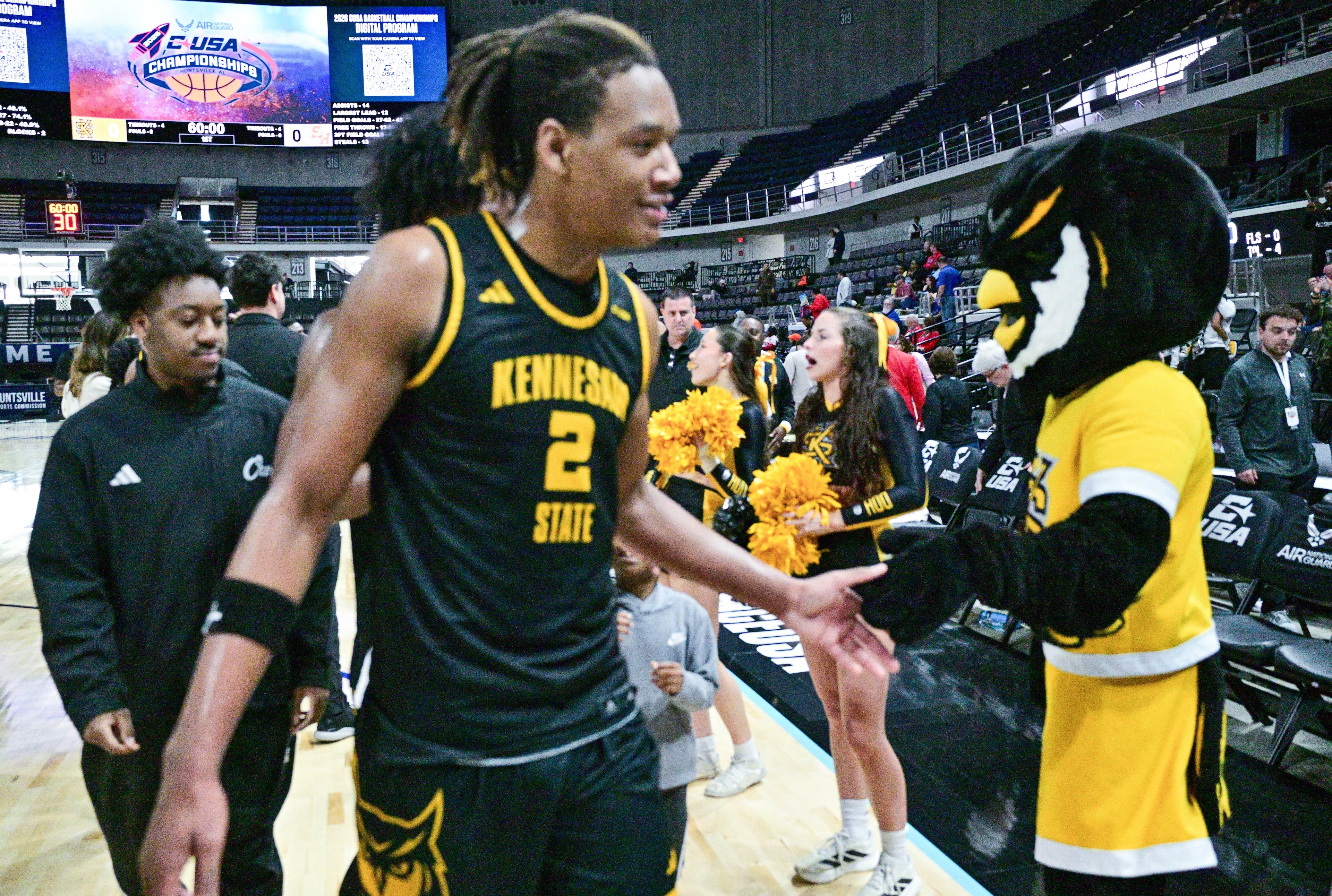 Kennesaw State’s Trey Simpson gets daps from mascot scrappy after a Conference USA Tournament semifinal win.