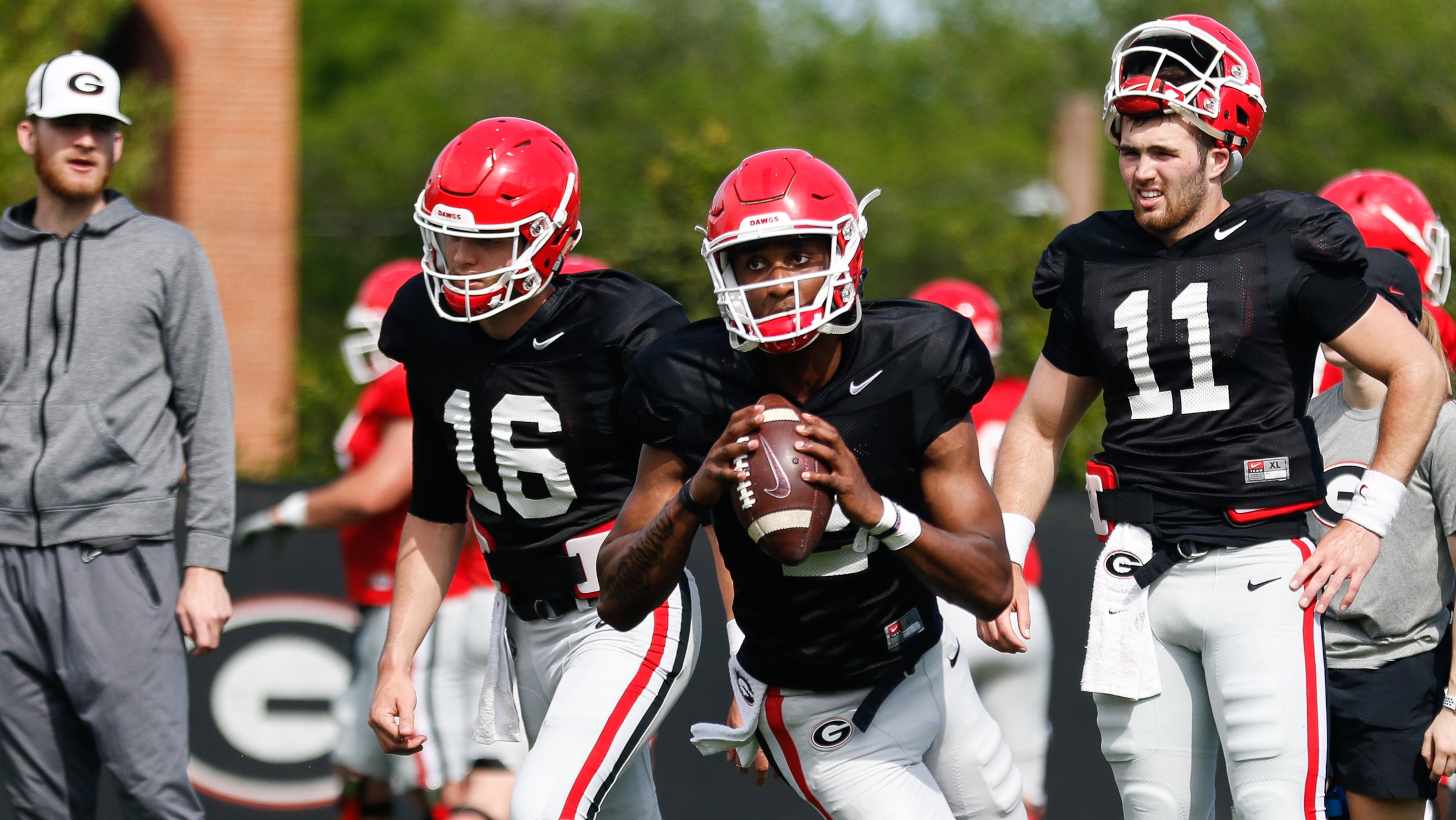 Georgia quarterback D'Wan Mathis (2) sets up for a pass - with teammates John Seter (16) and Jake Fromm (11) watching - during spring practice Tuesday, April 9, 2019, in Athens.