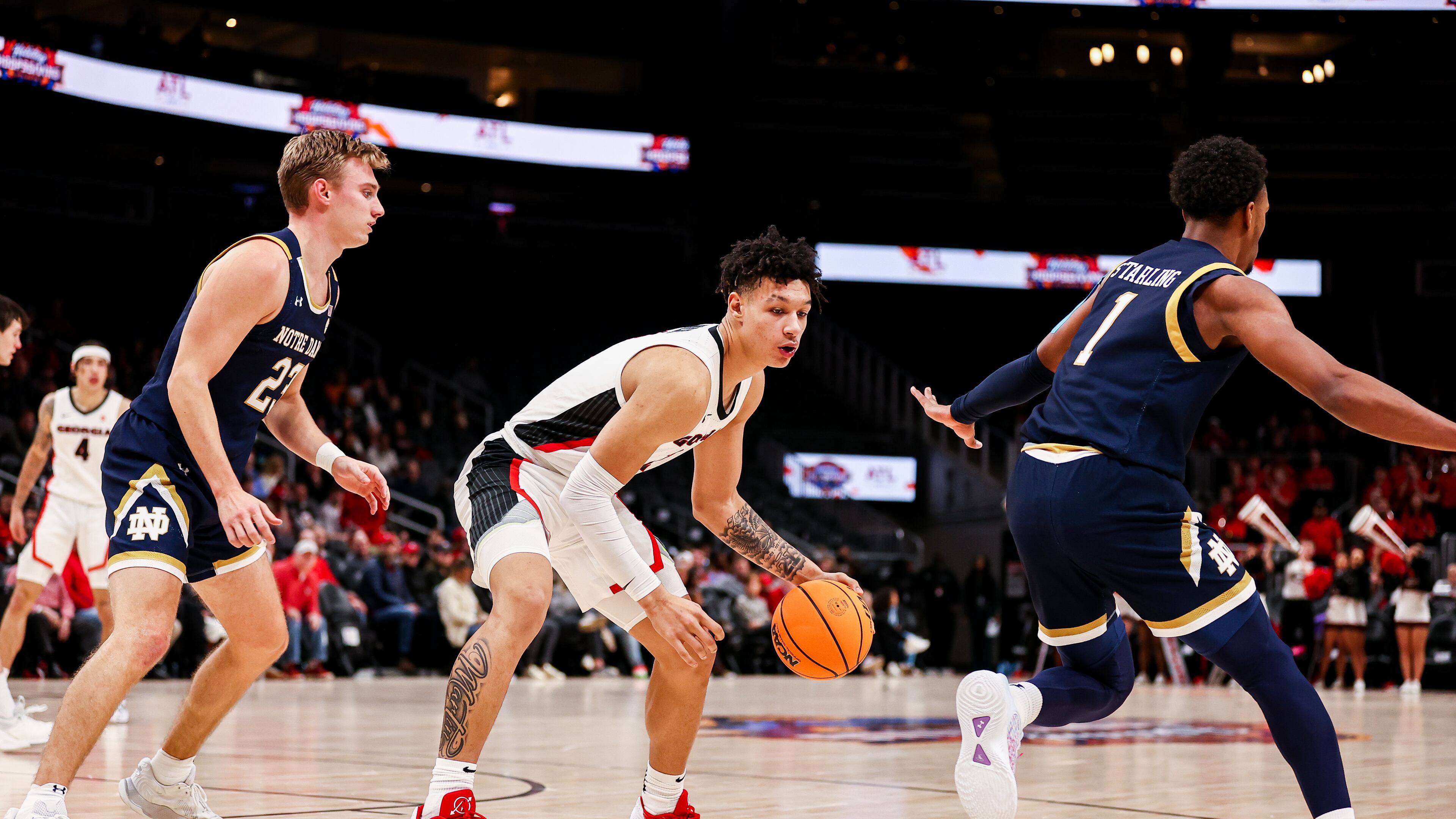 Georgia forward KyeRon Lindsay (2) dribbles between two Notre Dame defenders during their Holiday Hoopsgiving game at State Farm Arena in Atlanta on Dec. 18, 2022. (Photo by Tony Walsh/UGA Athletics)