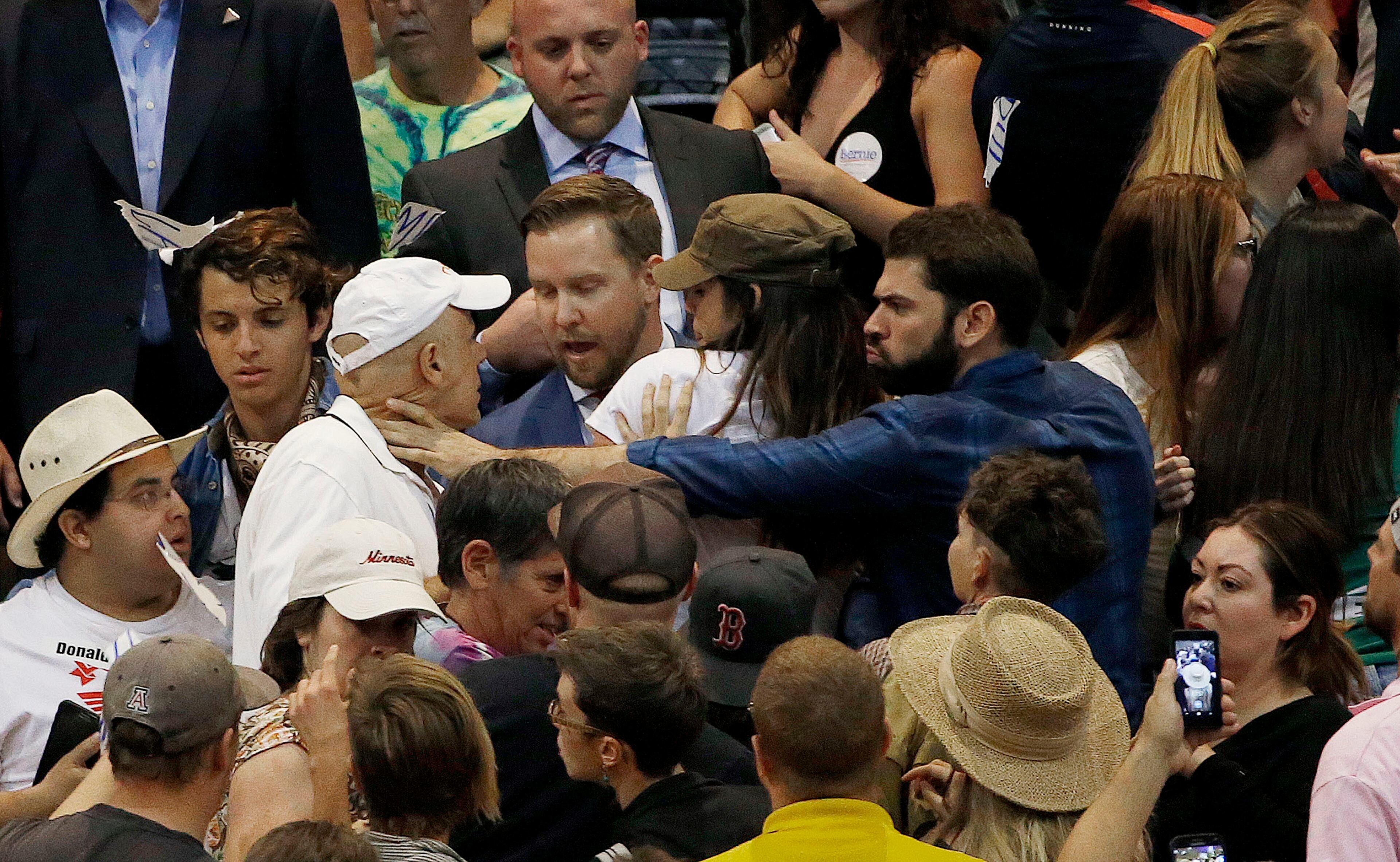 A supporter of Republican presidential candidate Donald Trump, left, is grabbed by an anti-Trump protester, right, during a scuffle as the candidate speaks during a campaign rally Saturday, March 19, 2016, in Tucson, Ariz. (AP Photo/Ross D. Franklin)