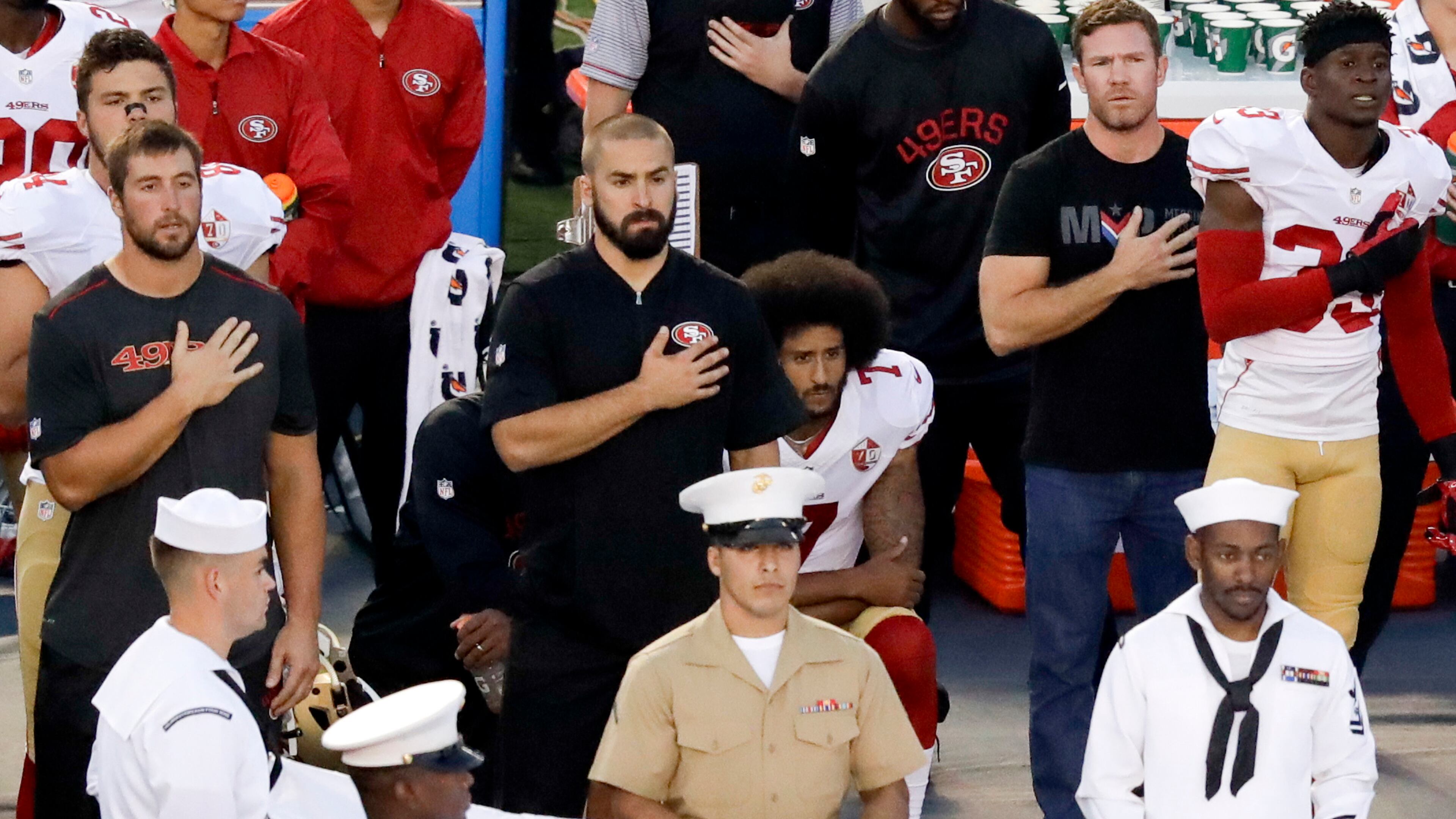 FILE - In this Thursday, Sept. 1, 2016, file photo, San Francisco 49ers quarterback Colin Kaepernick, center, kneels during the national anthem before an NFL preseason football game against the San Diego Chargers in San Diego. With Case Keenum and Blaine Gabbert set as starting quarterbacks, Kaepernick's refusal to stand for the anthem getting more public acceptance and the Rams mostly settled into their new home, much of the focus when the teams open the season on Monday night will be on the running backs. (AP Photo/Chris Carlson, File)