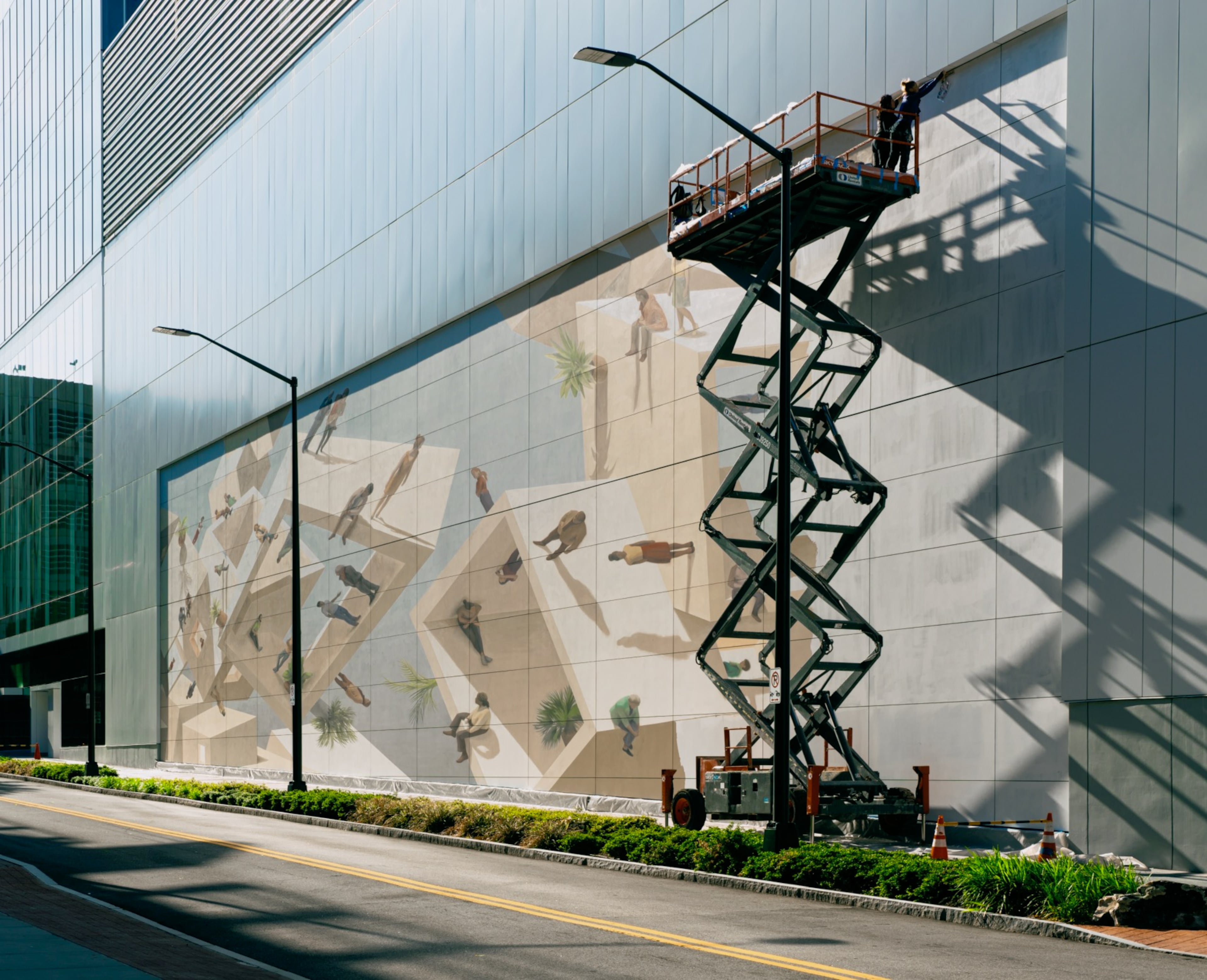 Artists Helena Salvador and Cinta Vidal worked 40 feet above Midtown on “Merge,” the streetscape mural that fills a wall of Coda Tech Square.
Courtesy of Brock Scott/Living Walls