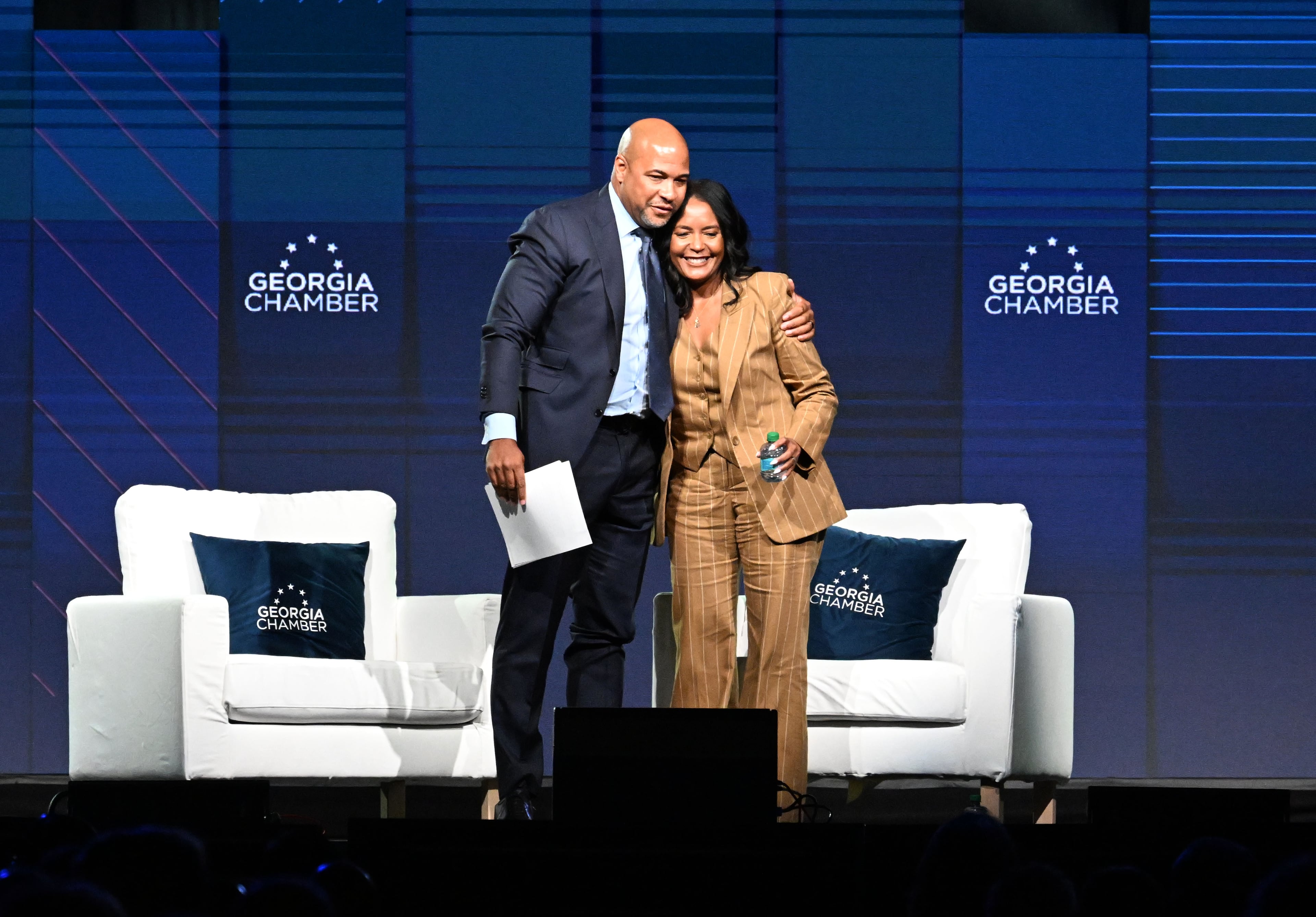 Democratic nominee for governor Keisha Lance Bottoms (right) gets a hug from moderator Tharon Johnson, founder and CEO of Paramount Consulting Group, after speaking during the Georgia Chamber Congressional Luncheon on Wednesday in Athens. (Hyosub Shin/AJC)